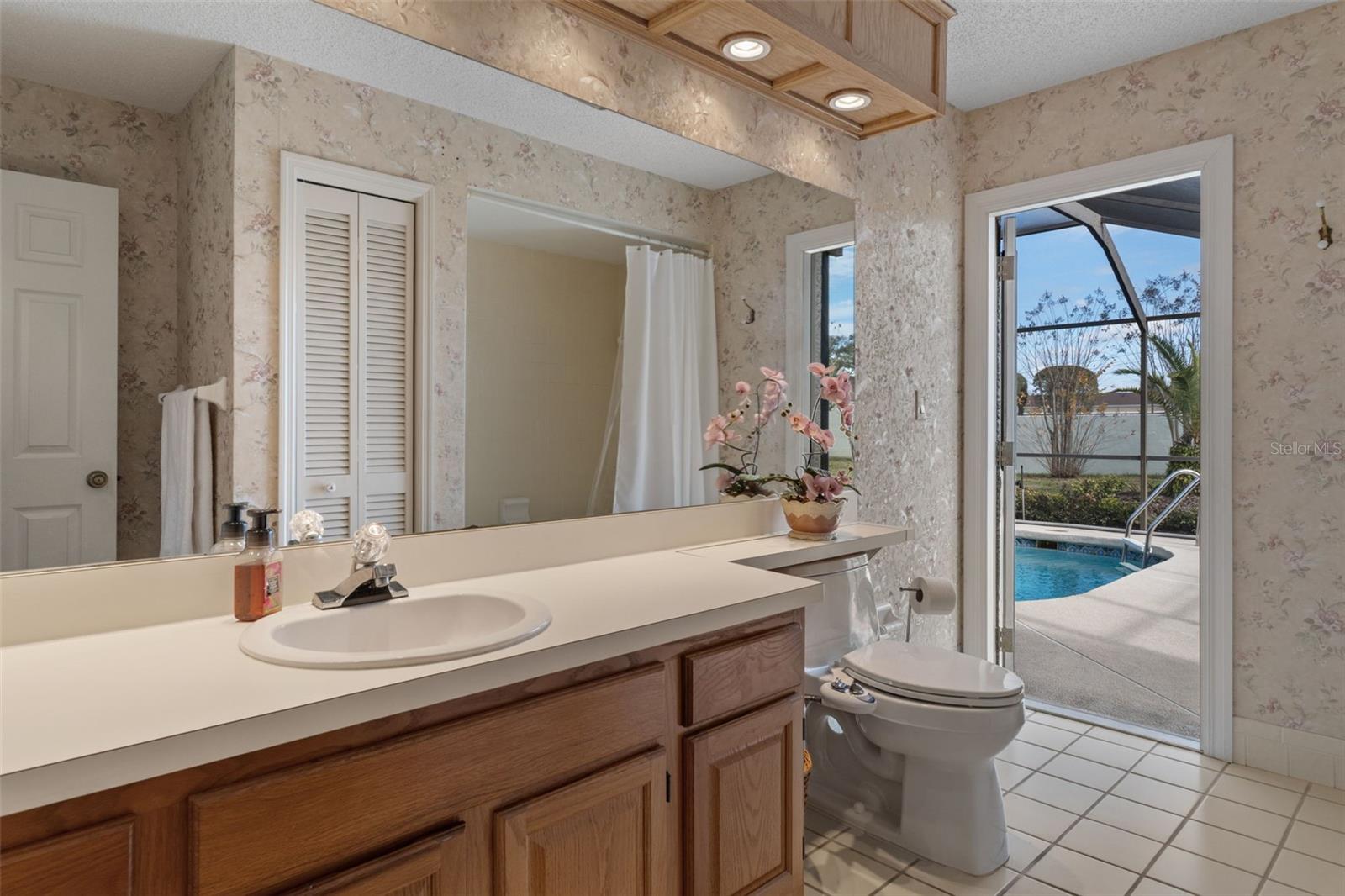 Secondary bathroom has a large vanity and doubles as a convenient pool bath with space for a small cabinet if desired.