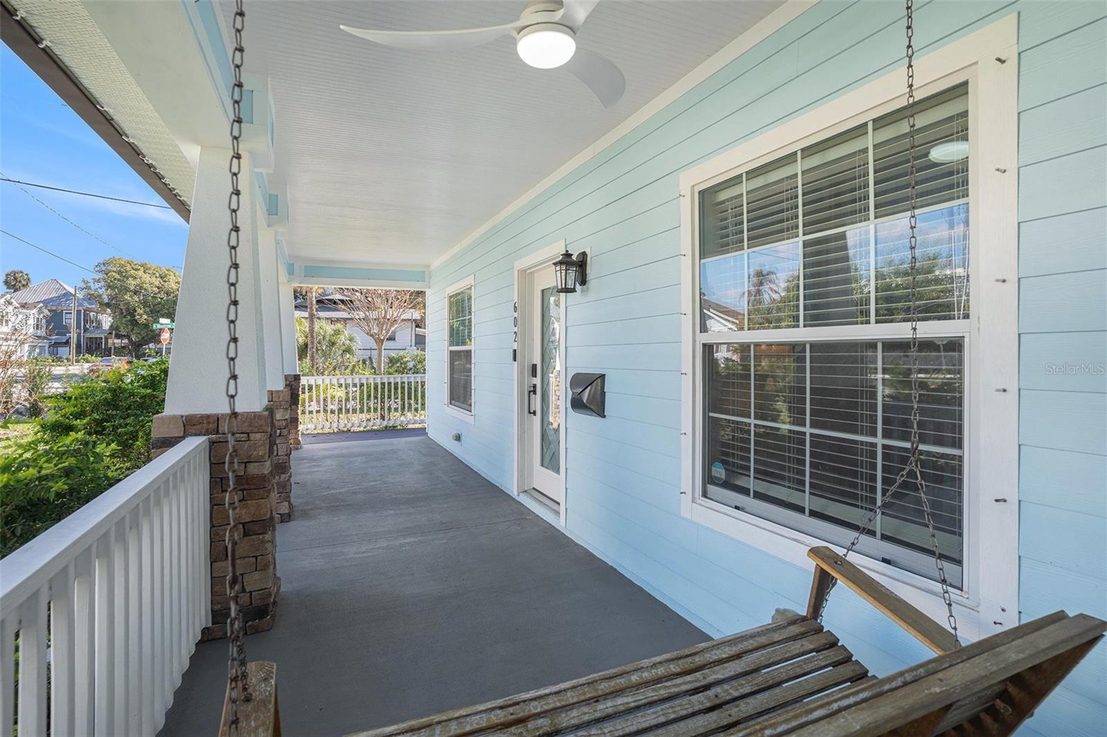 View of front patio with swing and ceiling fan included.