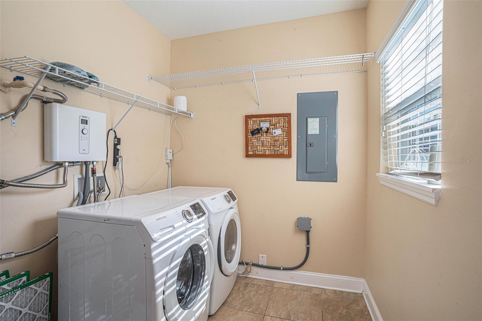 Laundry room with tankless water heater, washer and dryer included with home.