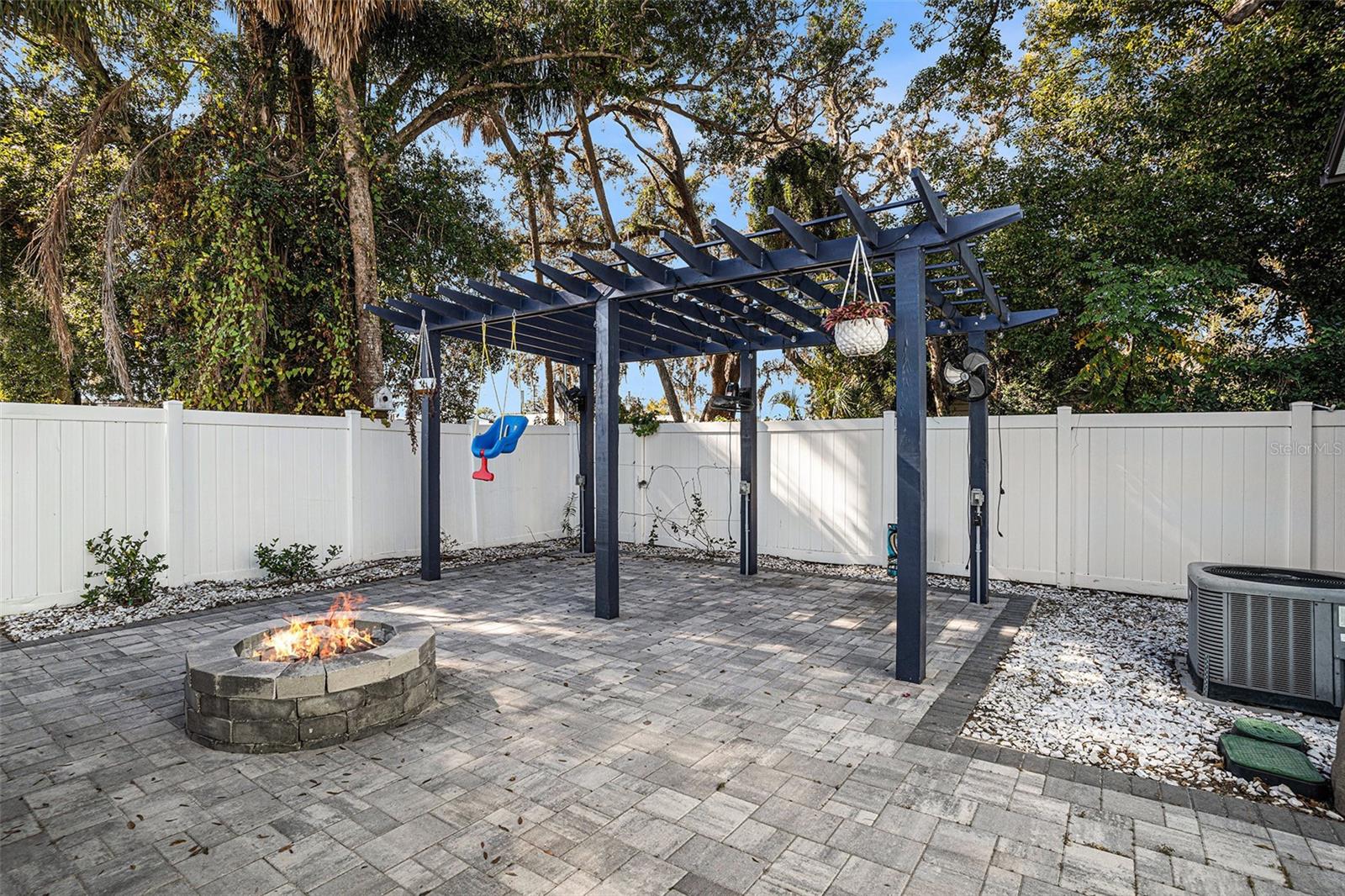 Backyard with pavers, fire pit, and pergola