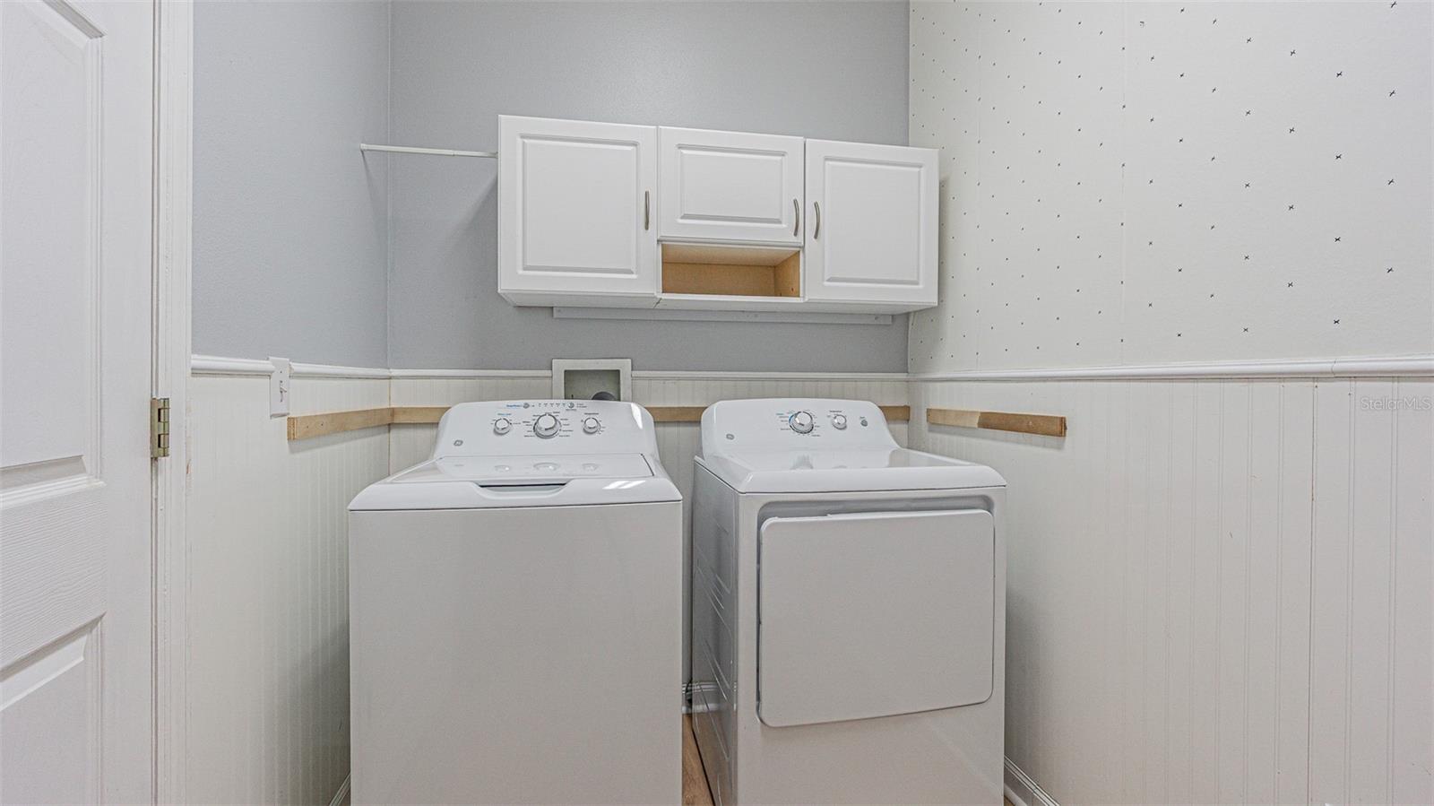 Interior laundry room with washer/dryer and storage above