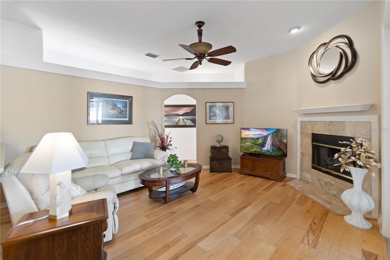living room with wood fireplace and french doors that lead out to the lanai