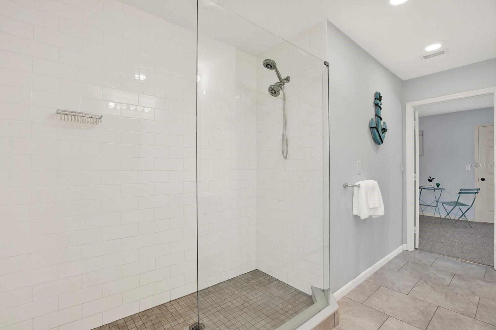 Spacious shower with dual shower heads.