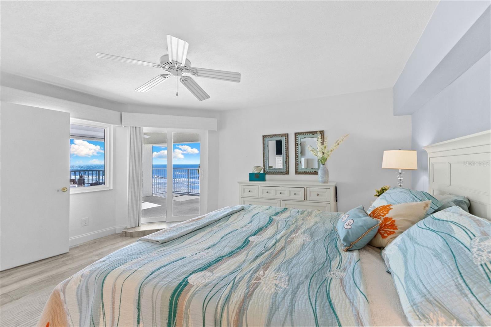PRIMARY BEDROOM WITH ACCESS TO THE COVERED LANI AND VIEWS OF THE GULF