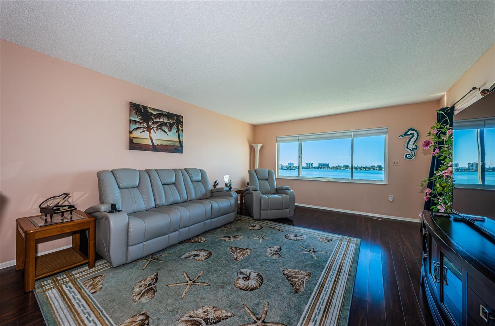 Living room with laminate flooring and solar blinds, plus HURRICANE shutters.