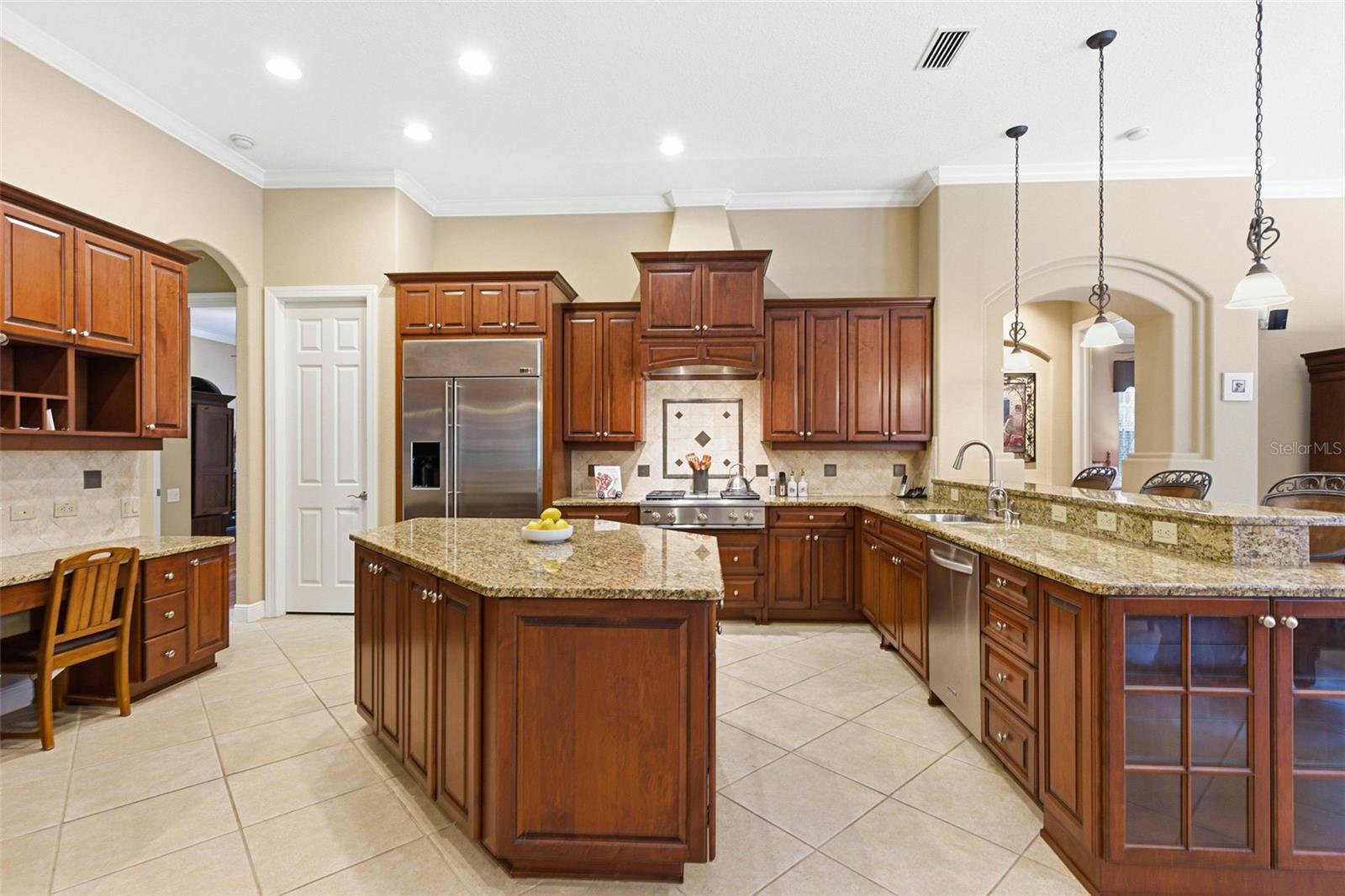 Gourmet kitchen features large island, pantry, breakfast bar