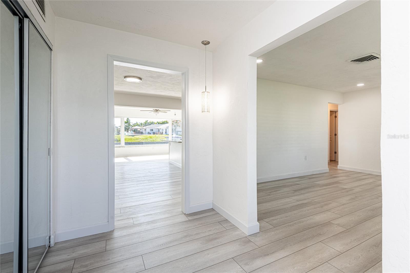 View from foyer with coat closet and opens to both kitchen and formal living room