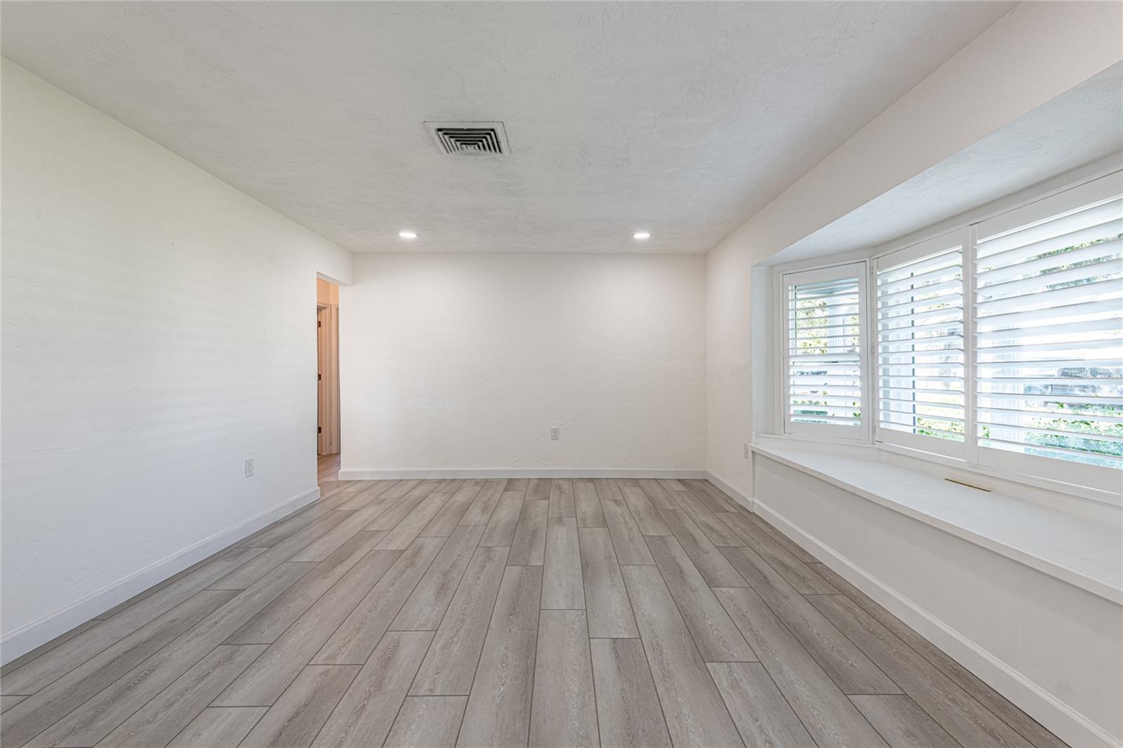 Living room with brand new bay window with seat and plantation shutters