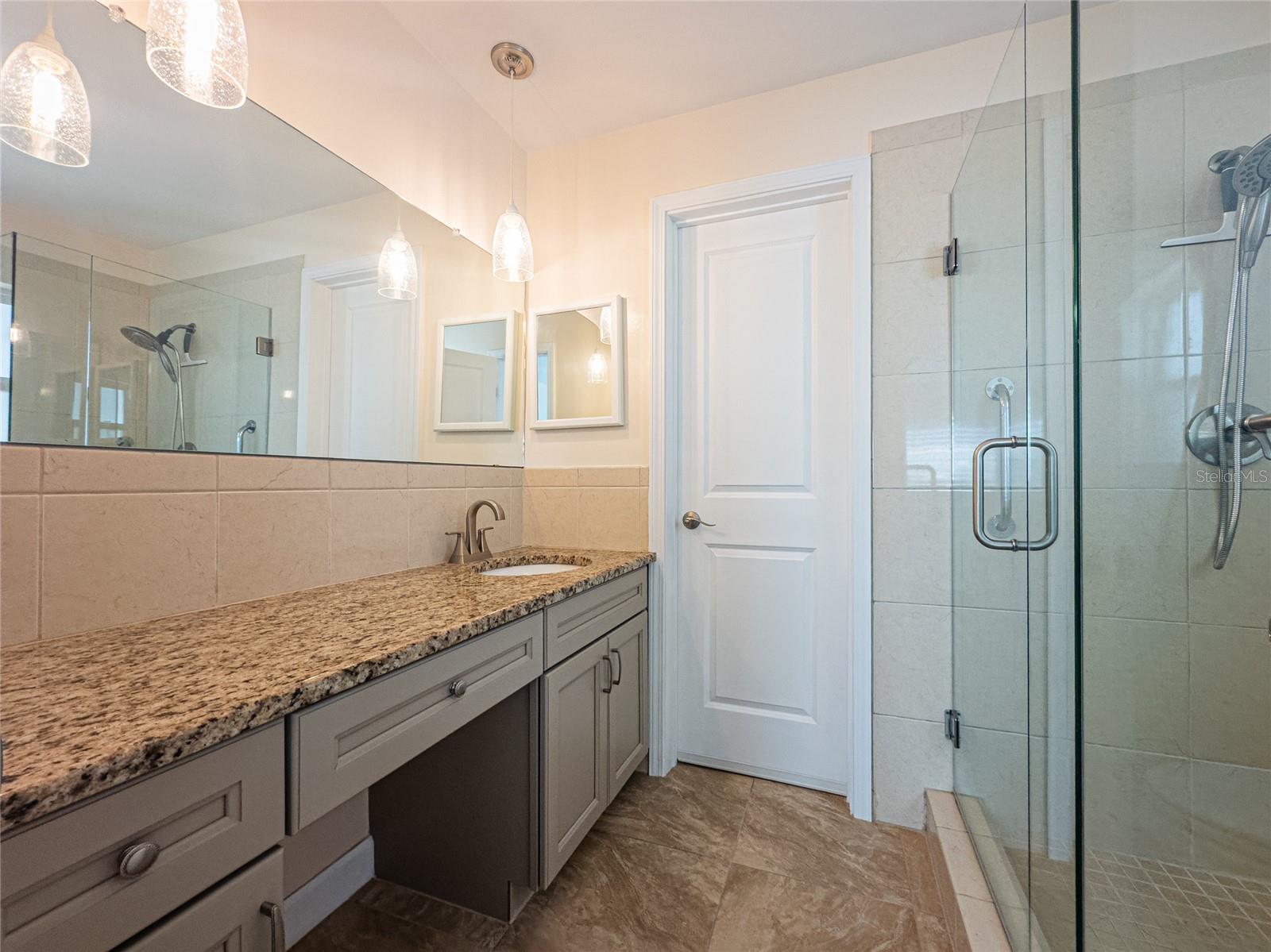 Primary bath with knee space and glass enclosed step-in shower