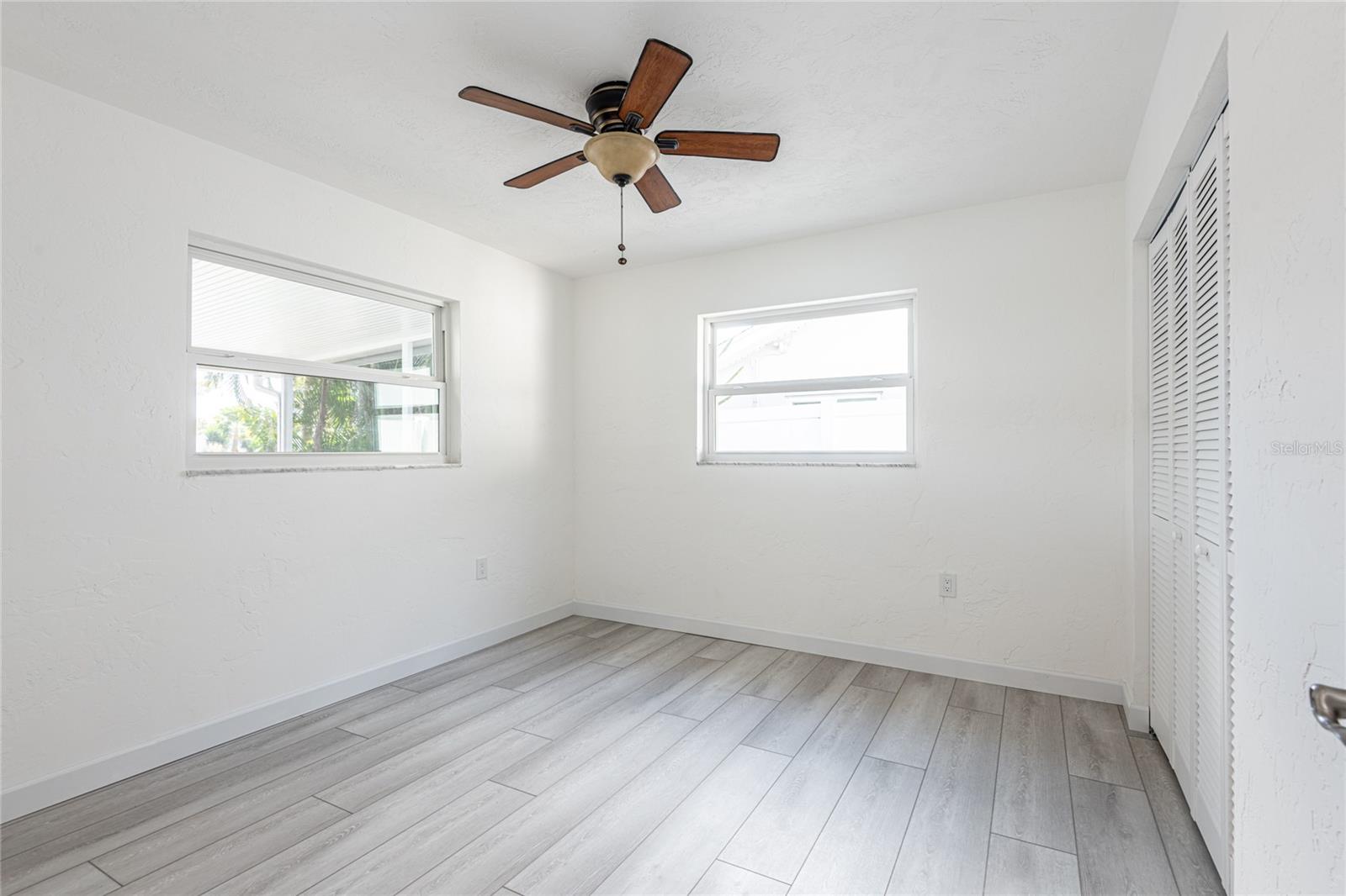 Bedroom 3 overlooks screened patio, back yard, and water