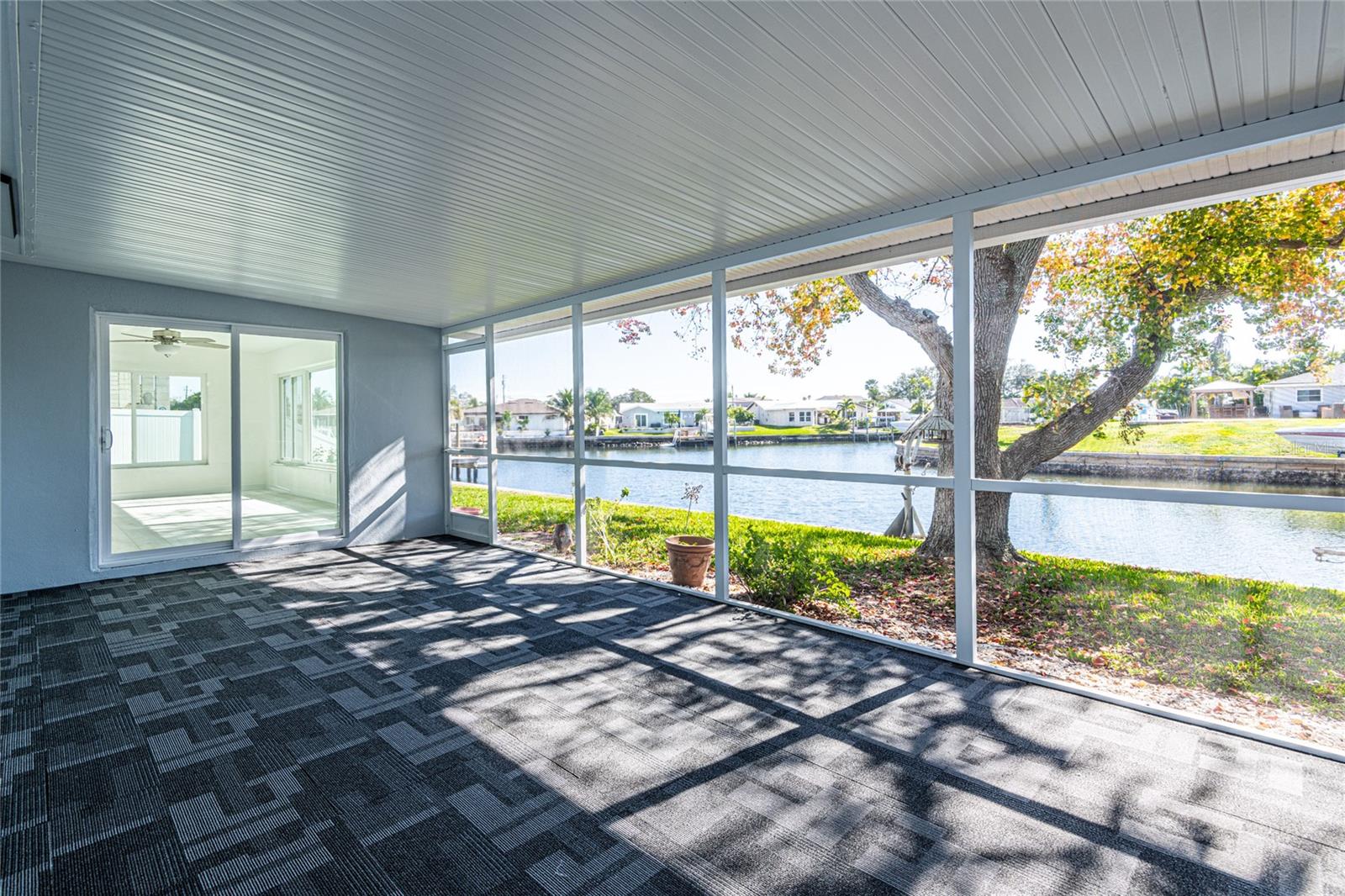 Step through new sliders to the oversized screened patio with new flooring and screens