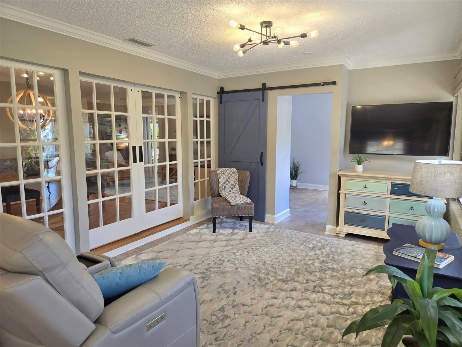 Custom sliding French doors can be closed off for sound separation. Note the Sputnik ceiling fixture!