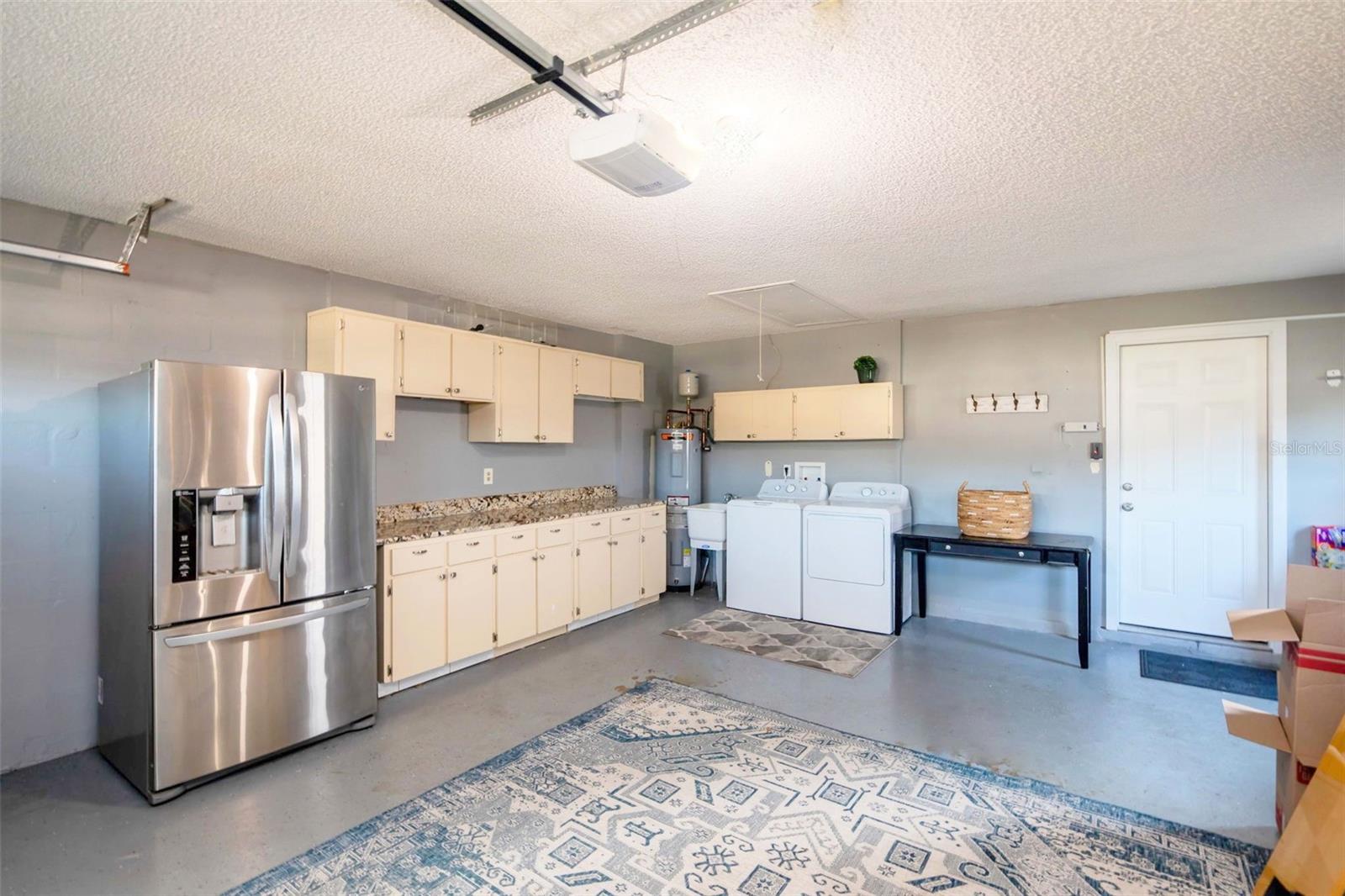 Oversize 2 car garage with laundry station, utility sink, room for folding table & a newer bonus fridge~