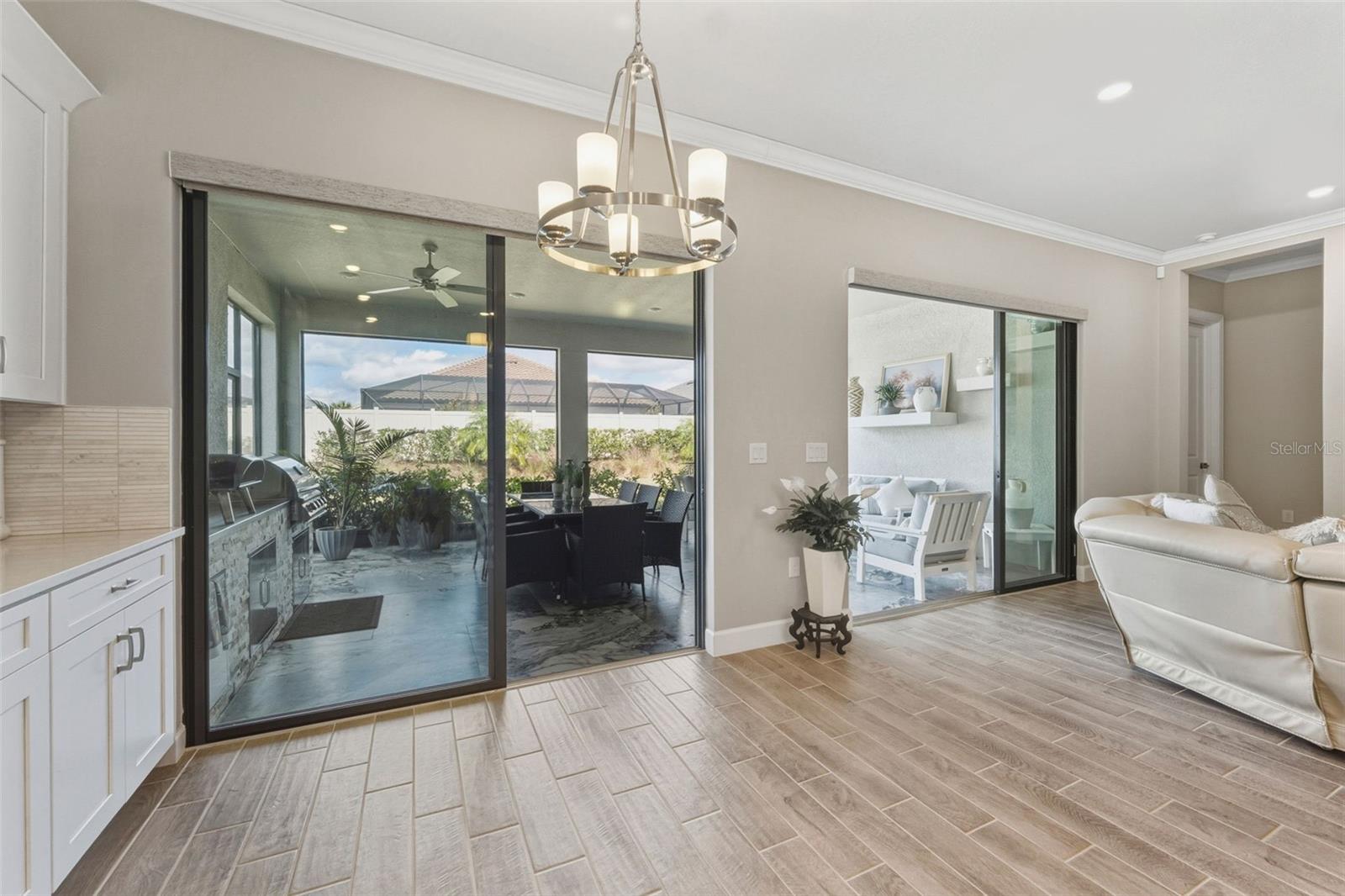 Sliding glass doors open to the extended and fully covered outdoor living area.