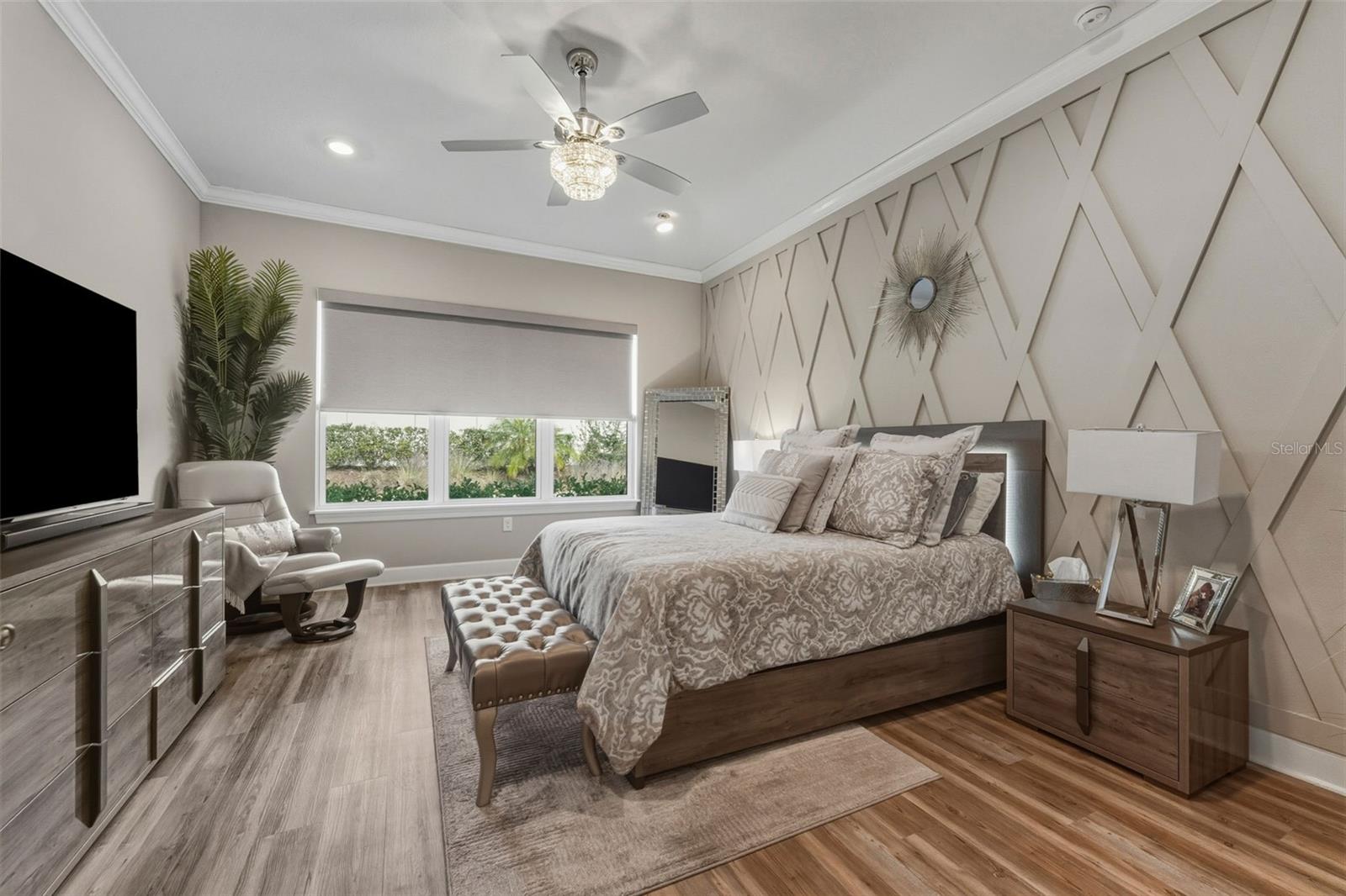 The primary bedroom has electronic blinds, crown molding and a custom wall for added warmth.
