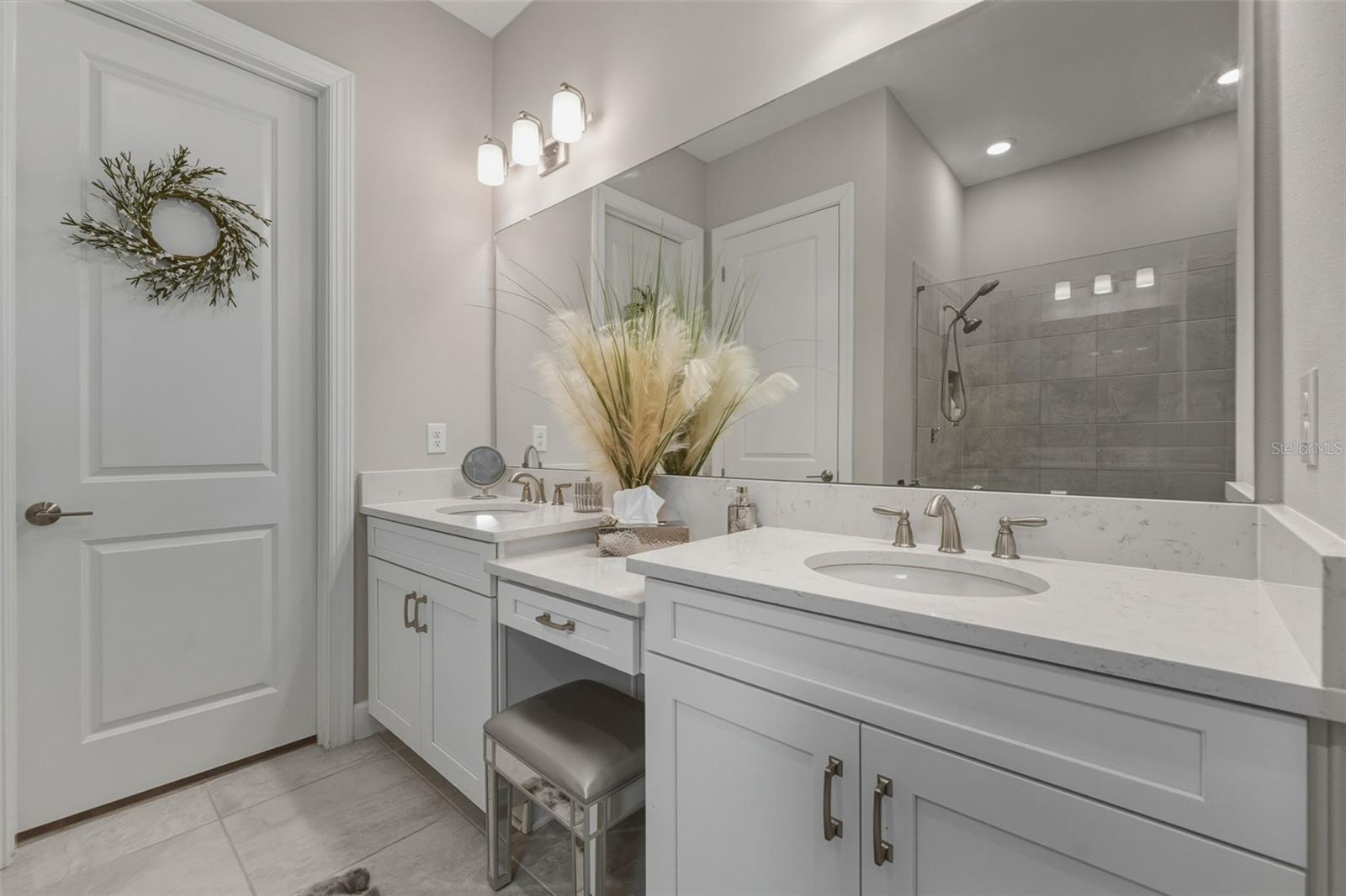 There are separate vanities with a make-up area in the primary bath.