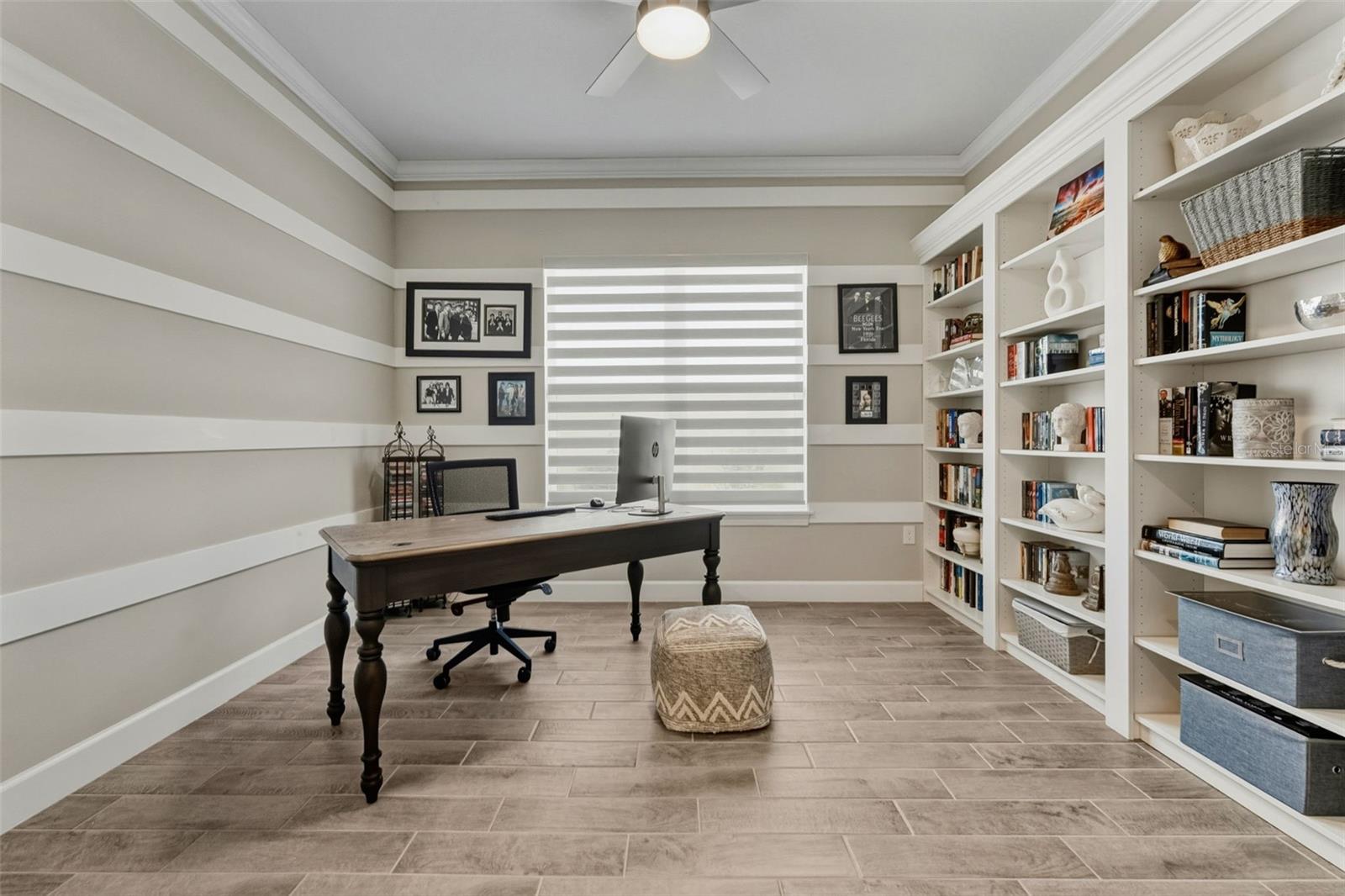 The den/office has built-in custom features with zebra shades allowing privacy and light filtering into the room.