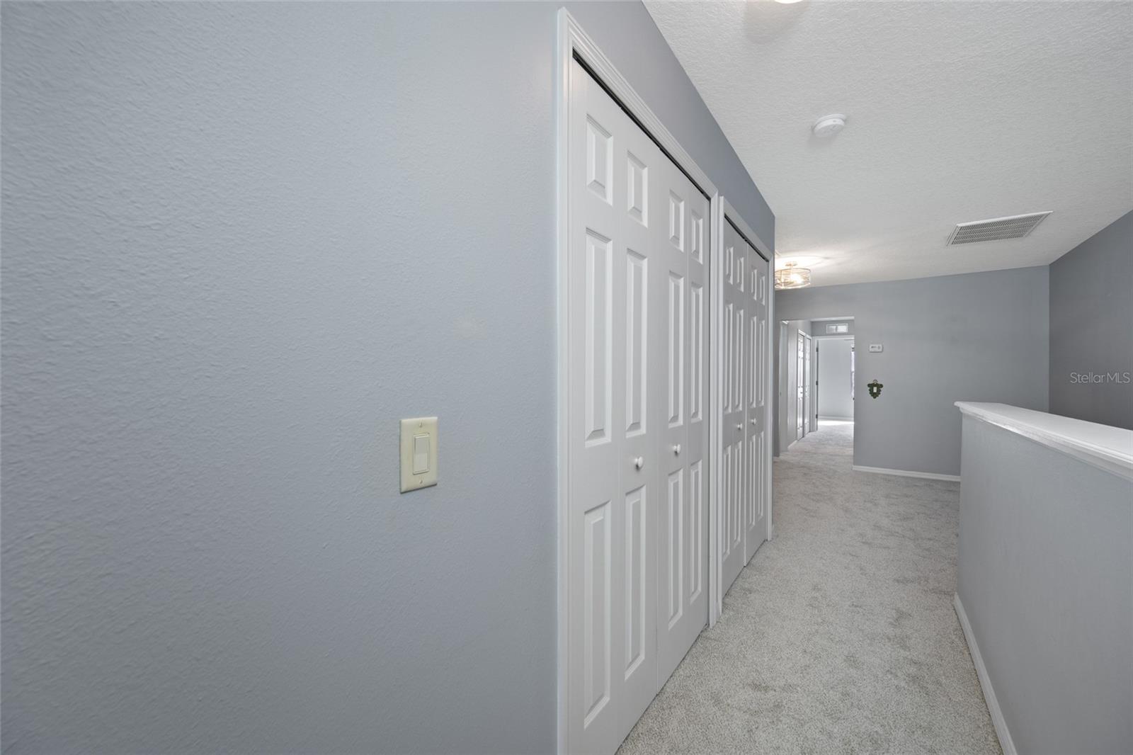 Dual closets in loft hallway