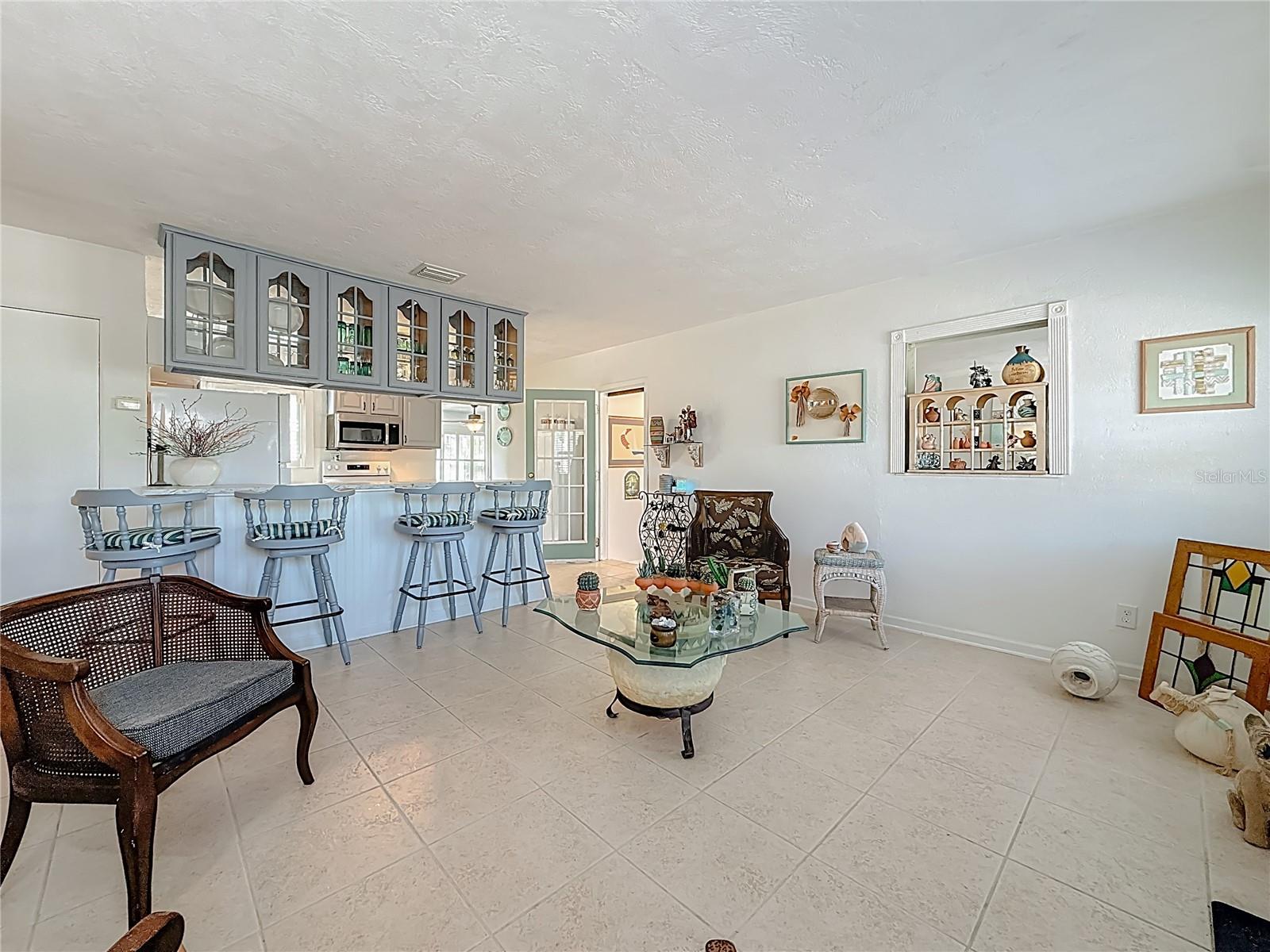 The living room opens up into the kitchen. Notice the nice glass inserts in the upper kitchen cabinets.