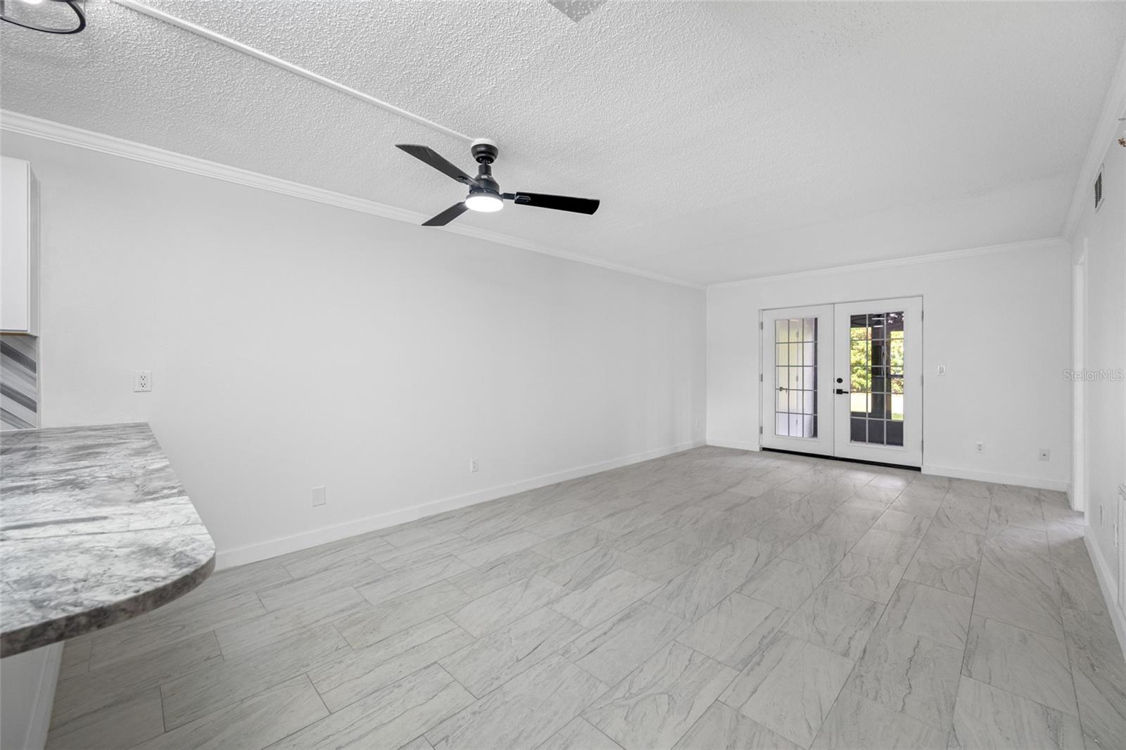 Living space with French doors connecting to encloses lanai.