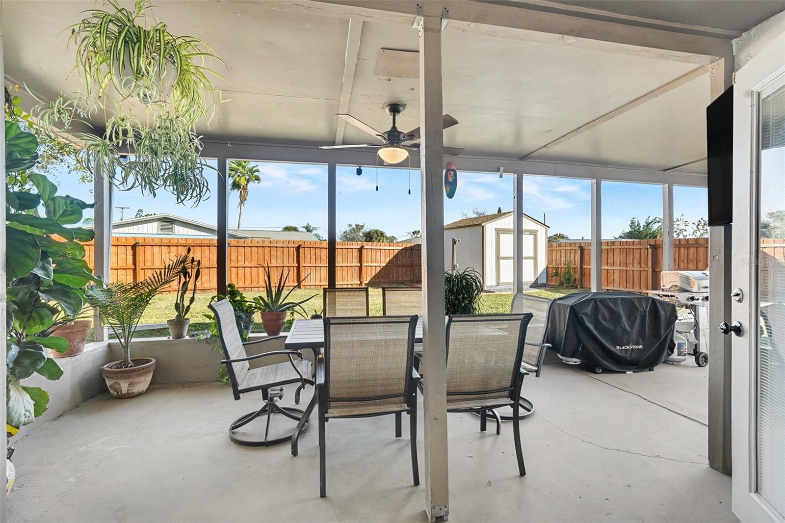 Expansive screened lanai offering shaded comfort, multiple seating areas, and seamless indoor-outdoor flow—perfect for gatherings year-round