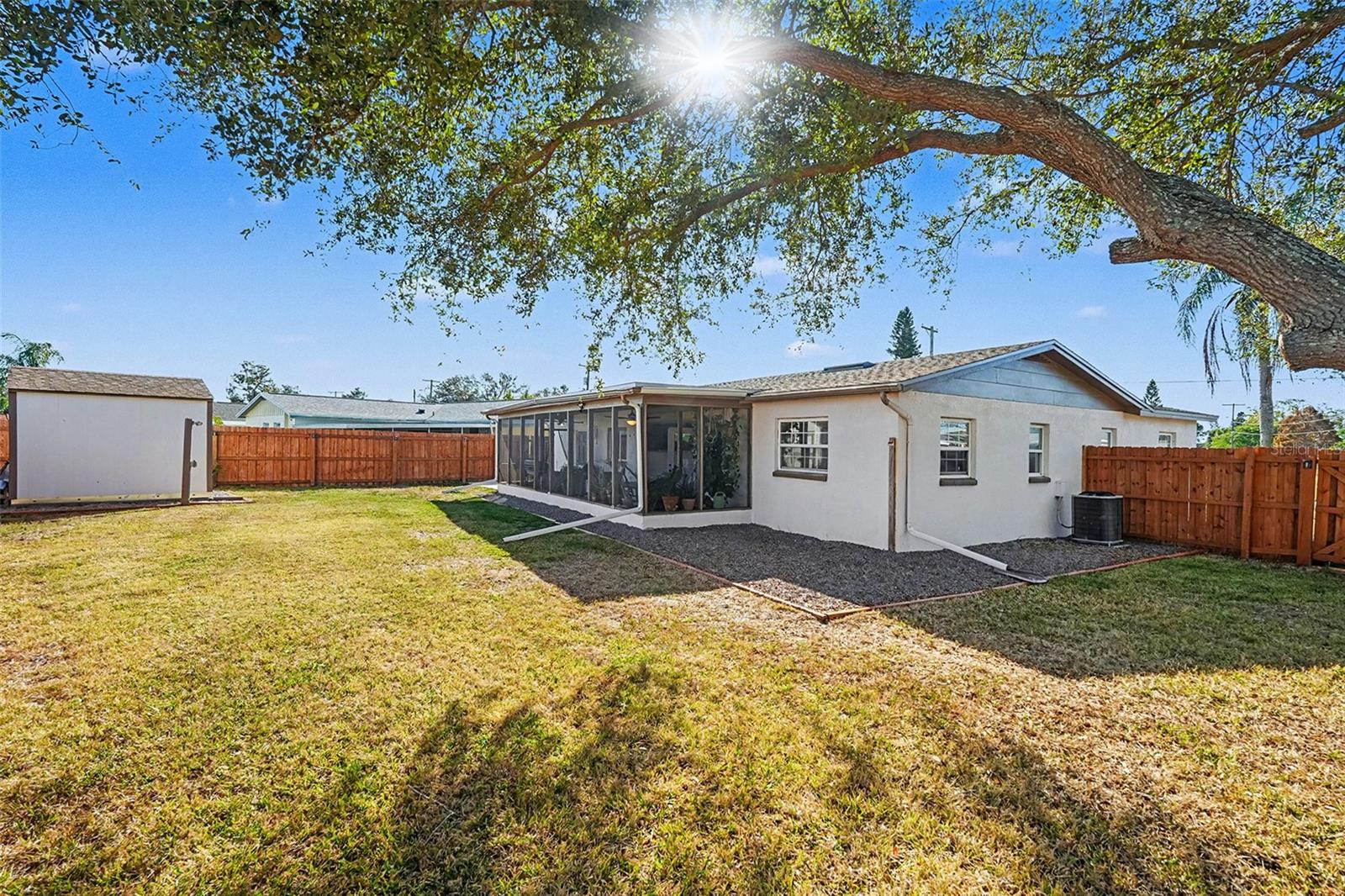 Private backyard with mature trees, fresh fencing, and ample open space for pets, play, or future outdoor enhancements.