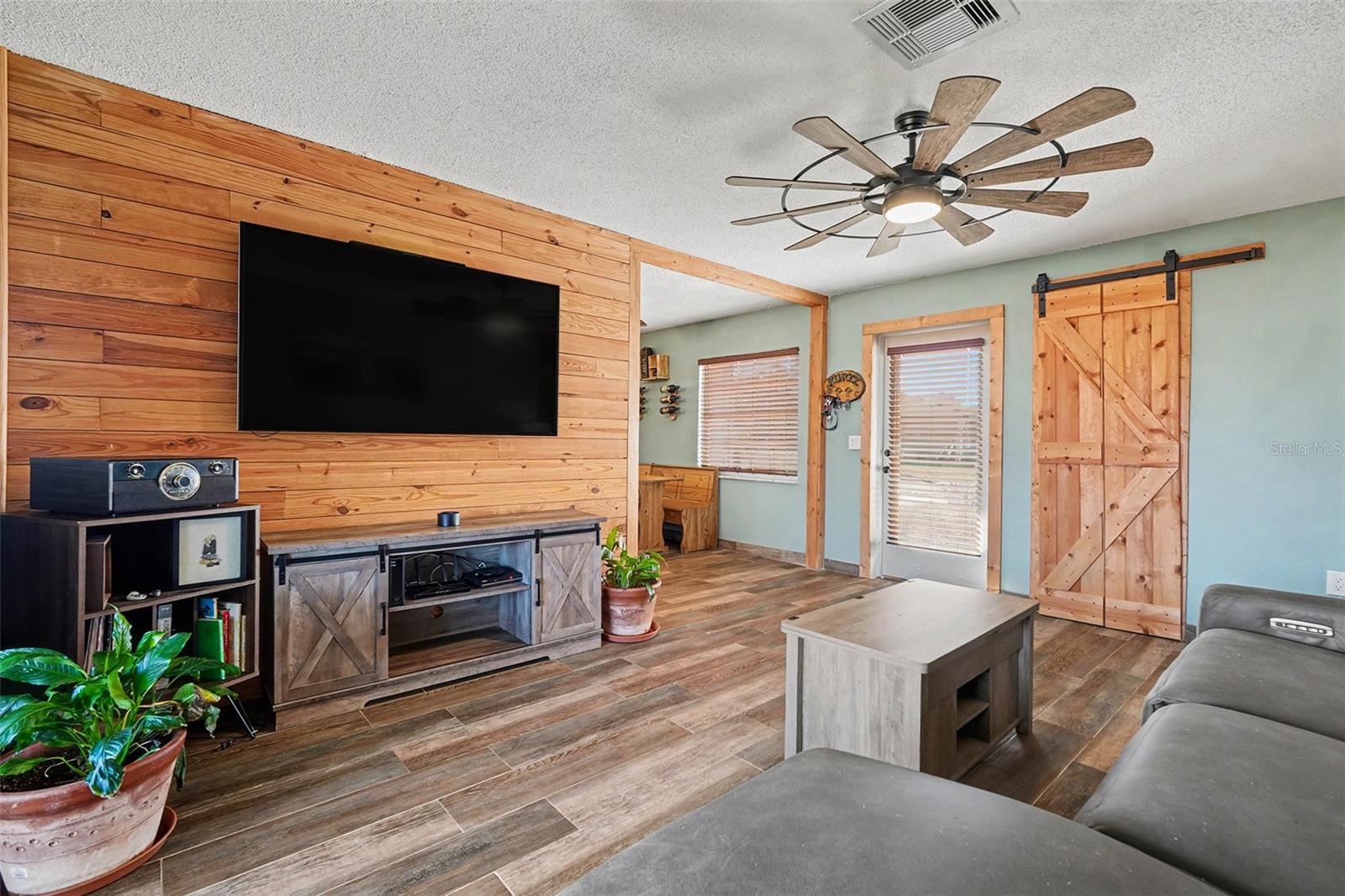 pen-concept living and dining layout with rustic design touches and flexible space for everyday living or hosting guests.