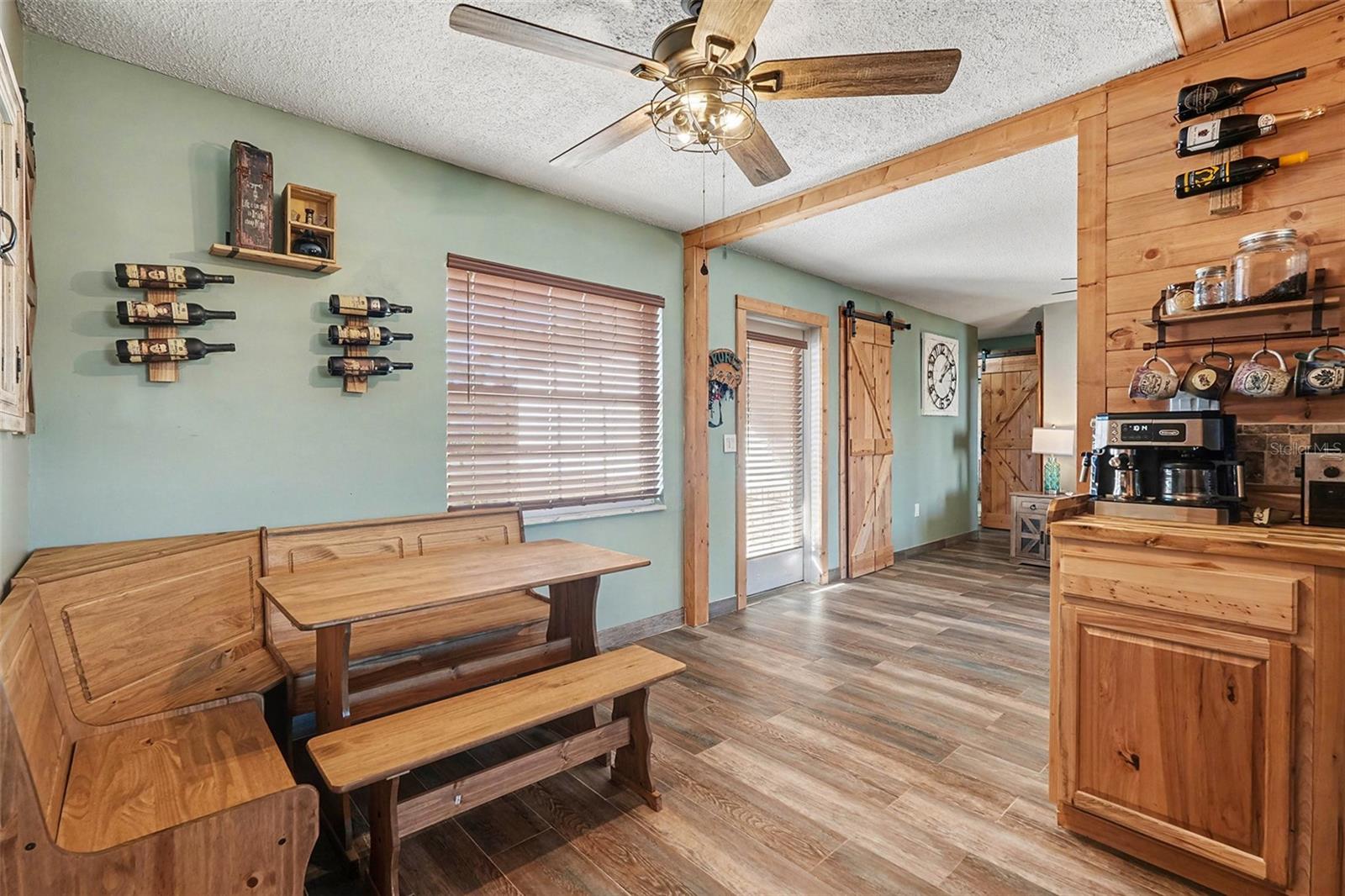 Kitchen and dining area featuring warm wood cabinetry, wood-look tile floors, and functional layout for everyday use.