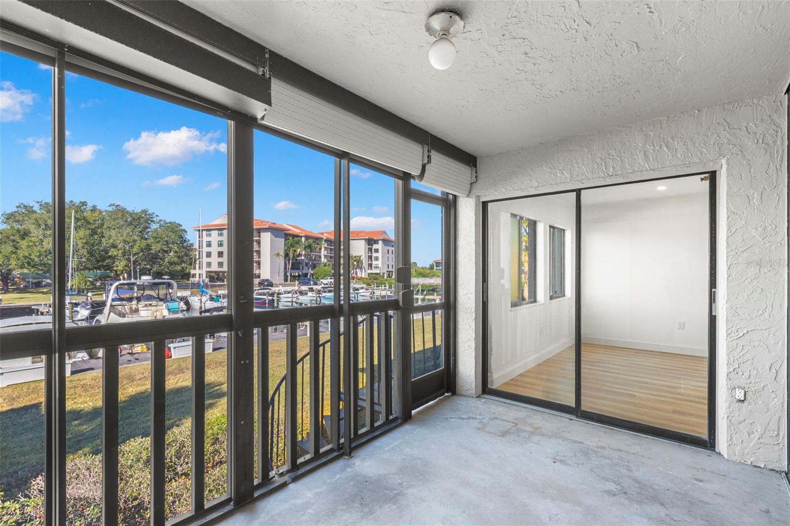 Screened balcony facing the marina and Gulf with sliders from the living room and the primary bedroom. Screen door opens to a spiral staircase that takes you right out to the boats on the main level.