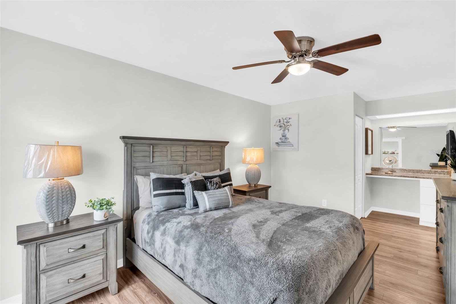 Spacious primary featuring two walk-in closets, en-suite bath, and make-up/vanity~