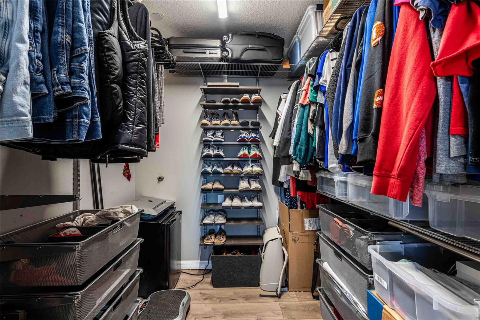 Primary walk in closet with custom built ins