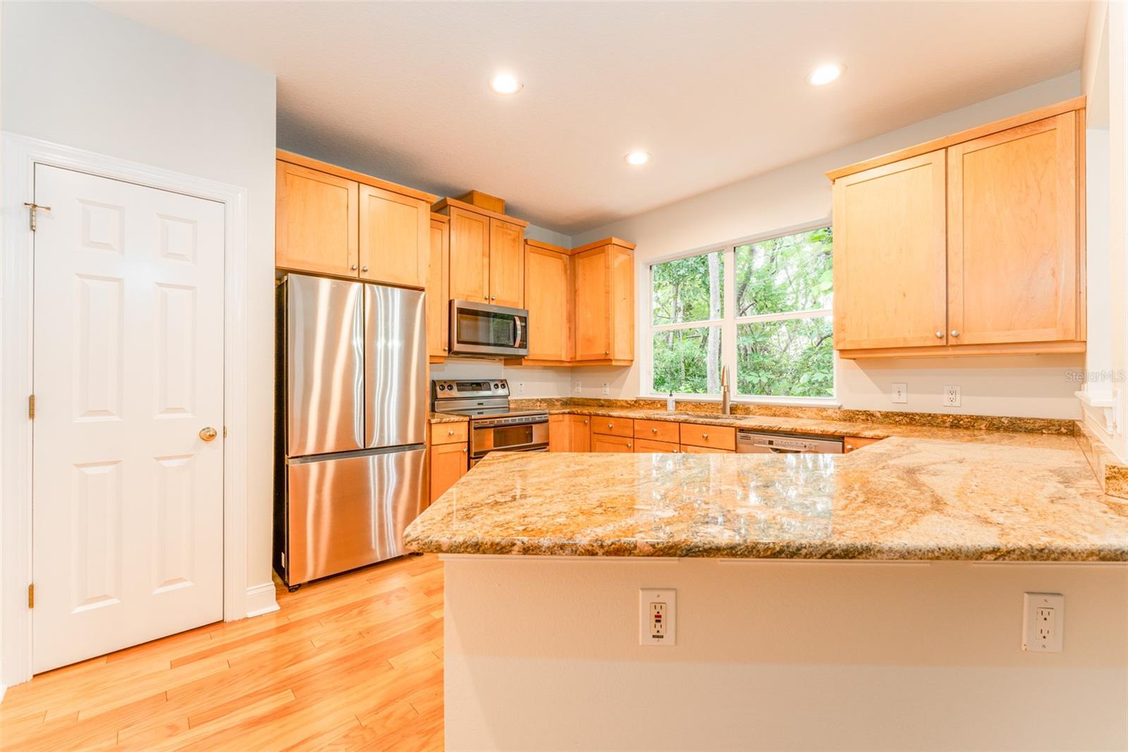 Well Equipped Kitchen with Wood Cabinetry, SS Appliances & Stone Counter Tops