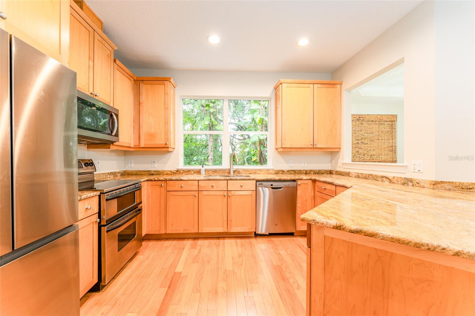 Well Equipped Kitchen with Wood Cabinetry, SS Appliances & Stone Counter Tops
