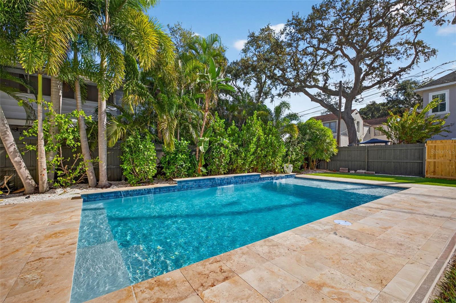 Salt water pool with sun shelf surrounded by Travertine decking and three waterfalls