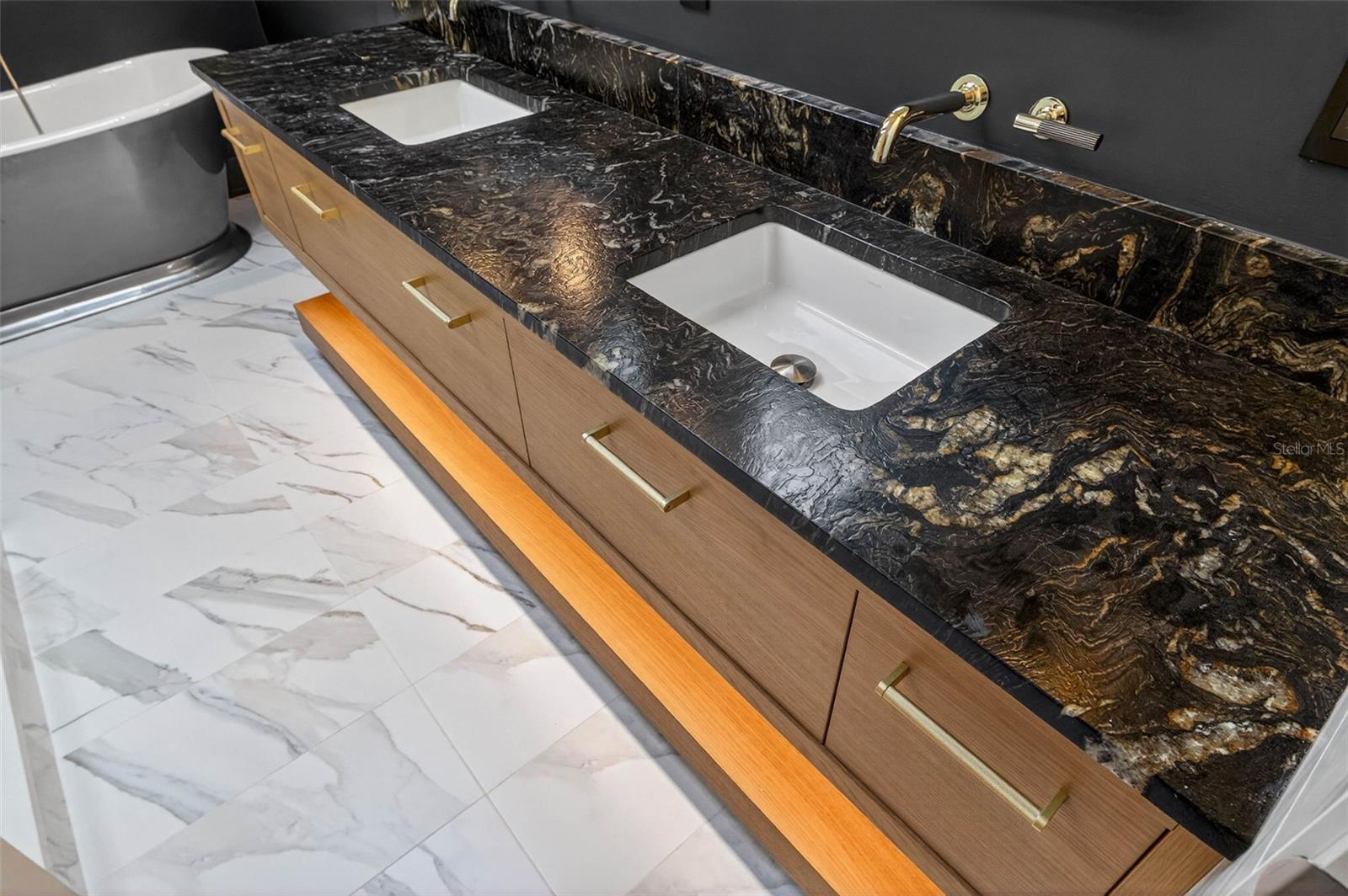 Custom built double vanity with sensor night lights, leathered counter, Wall mount fixtures, and ample storage!