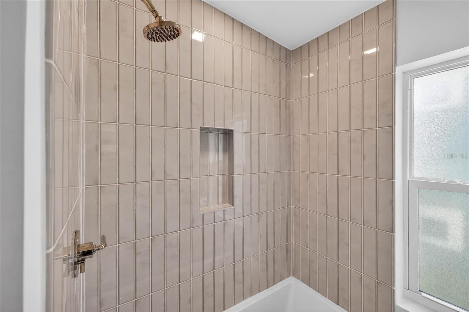 Bathroom two with designer tile and deep tub.