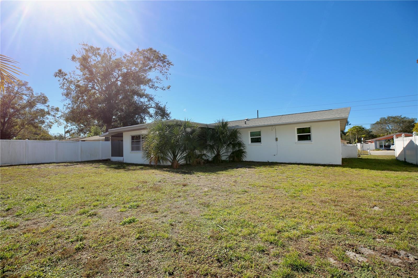Large fenced in yard with large white fence