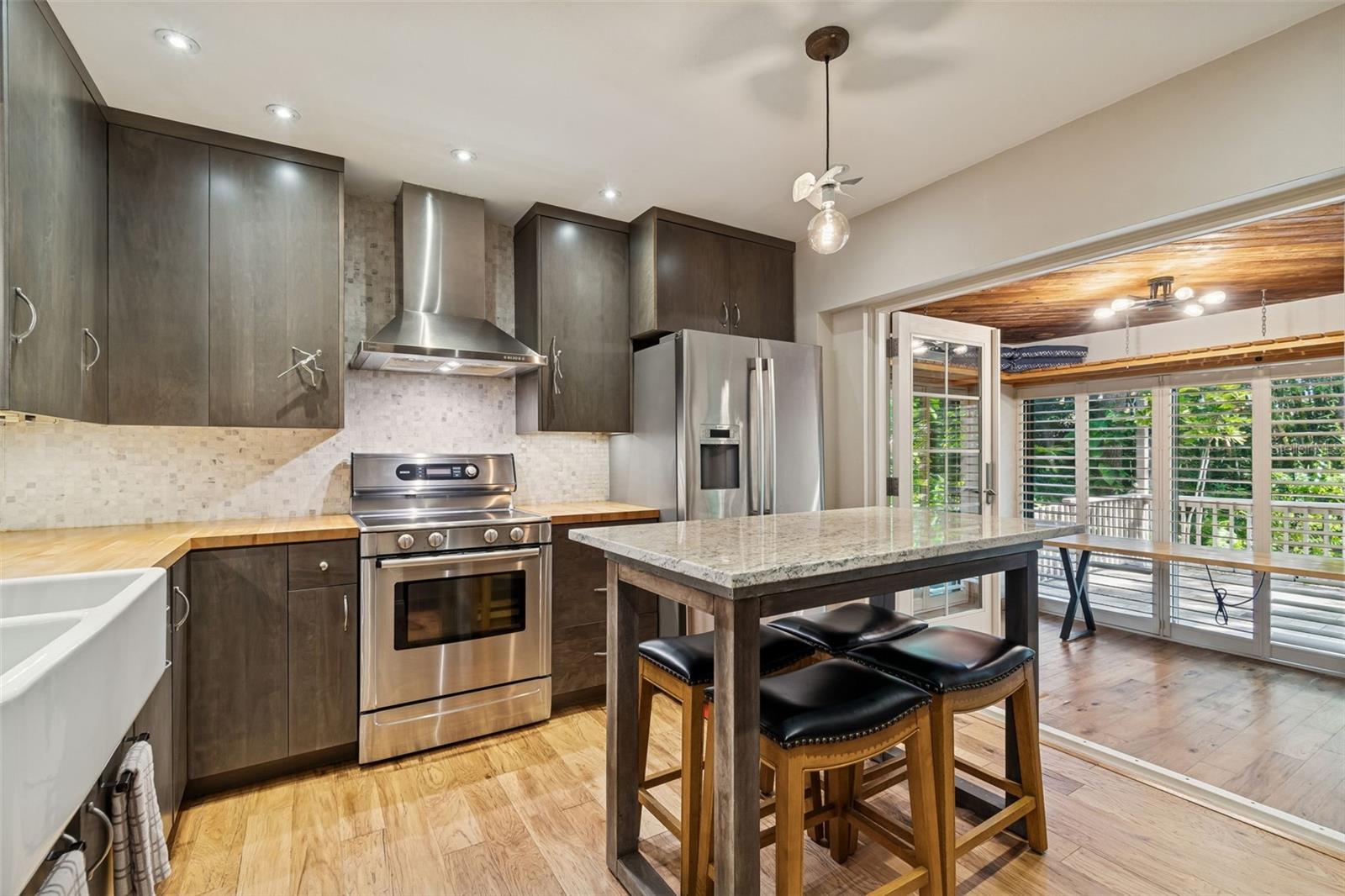 Custom kitchen with doors to sun room w/ doors to deck