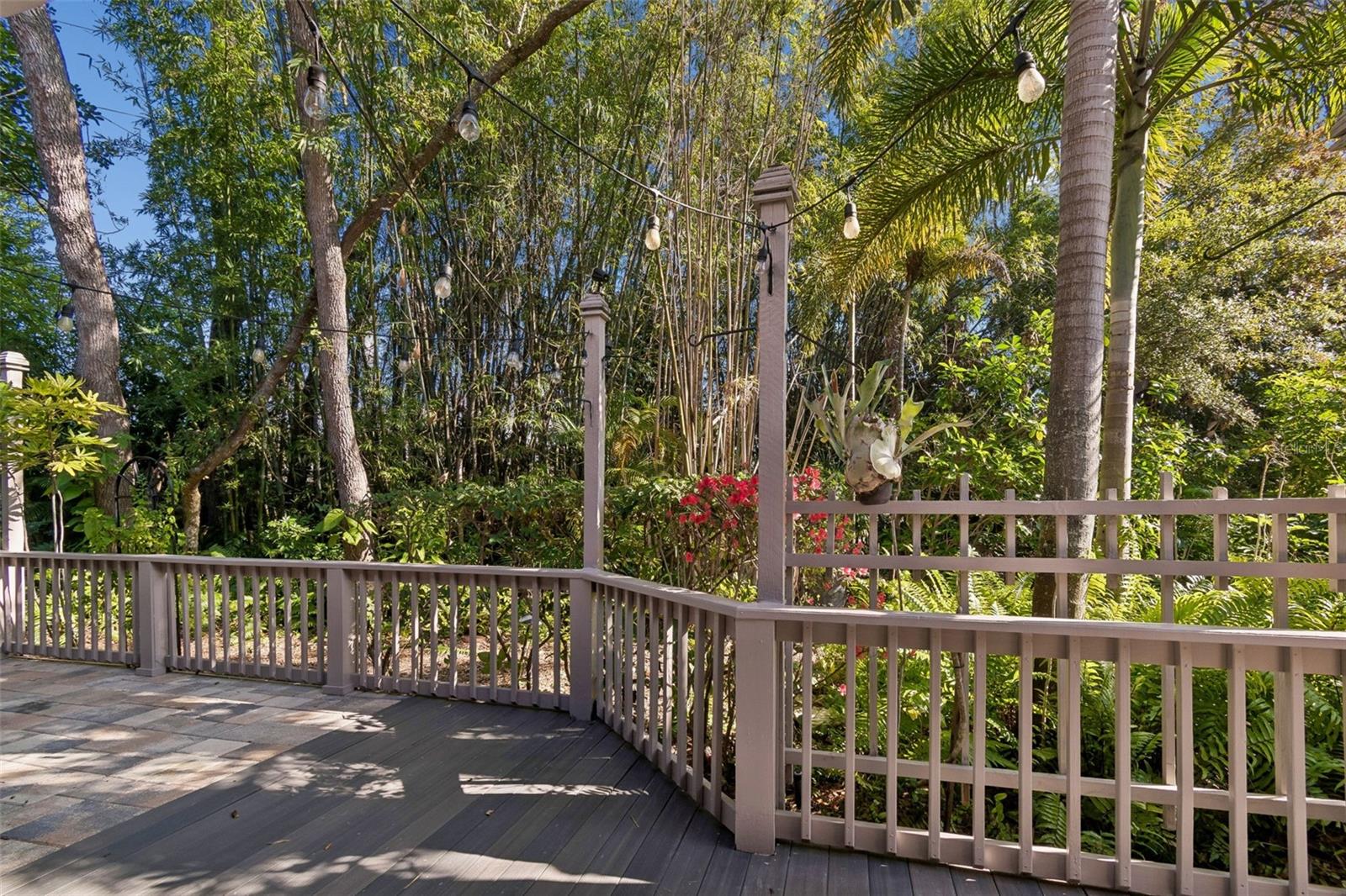 Private back deck surrounded by lush landscape