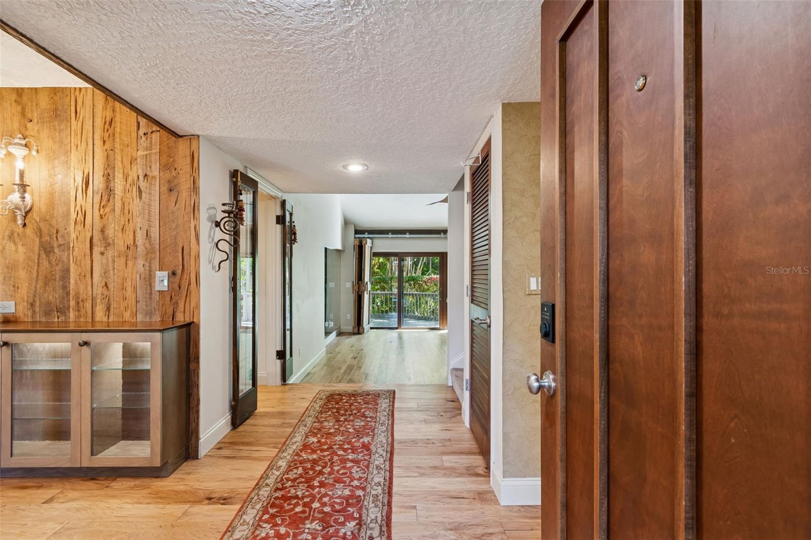 View from front door straight to family room sliders out to back, dining on left