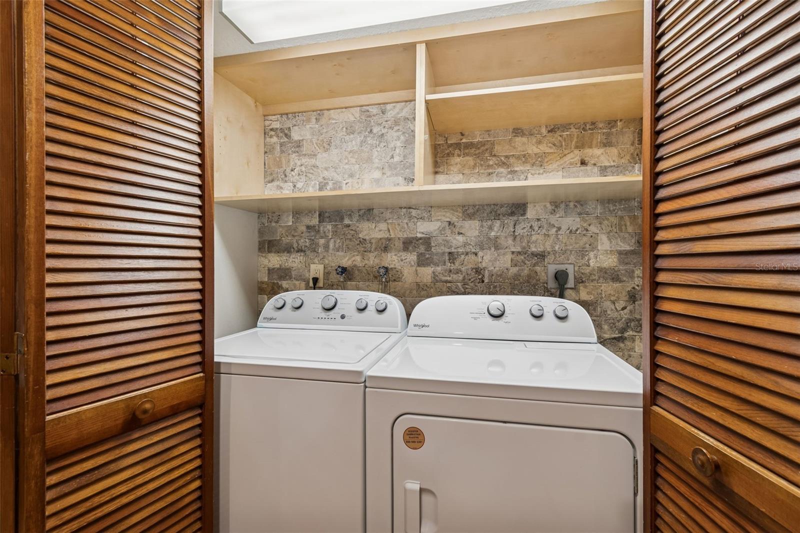 Laundry on 2nd level with built-in shelving and accent wall