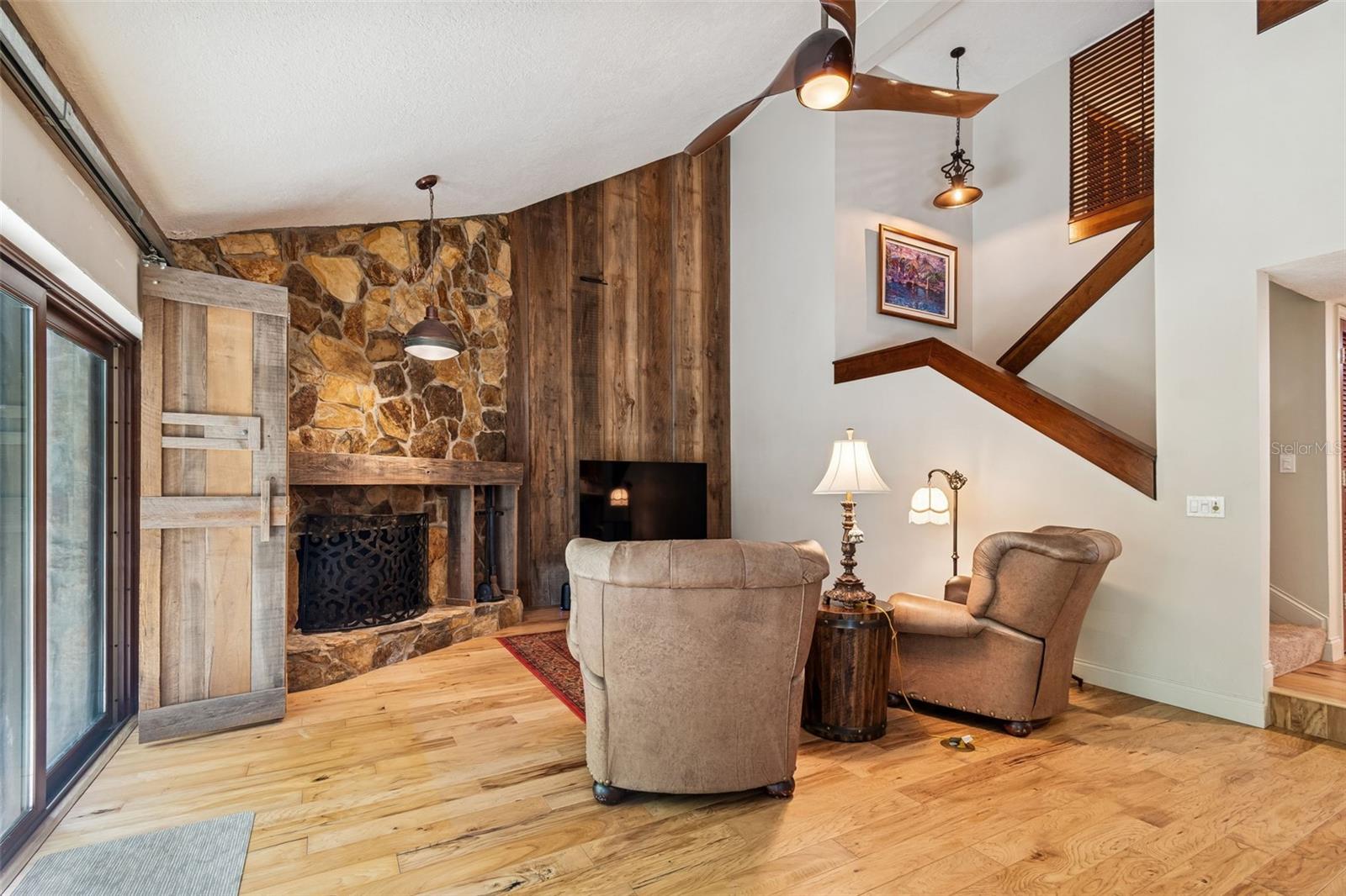 Family Room with vaulted ceiling, custom wood wall, FP, sliders