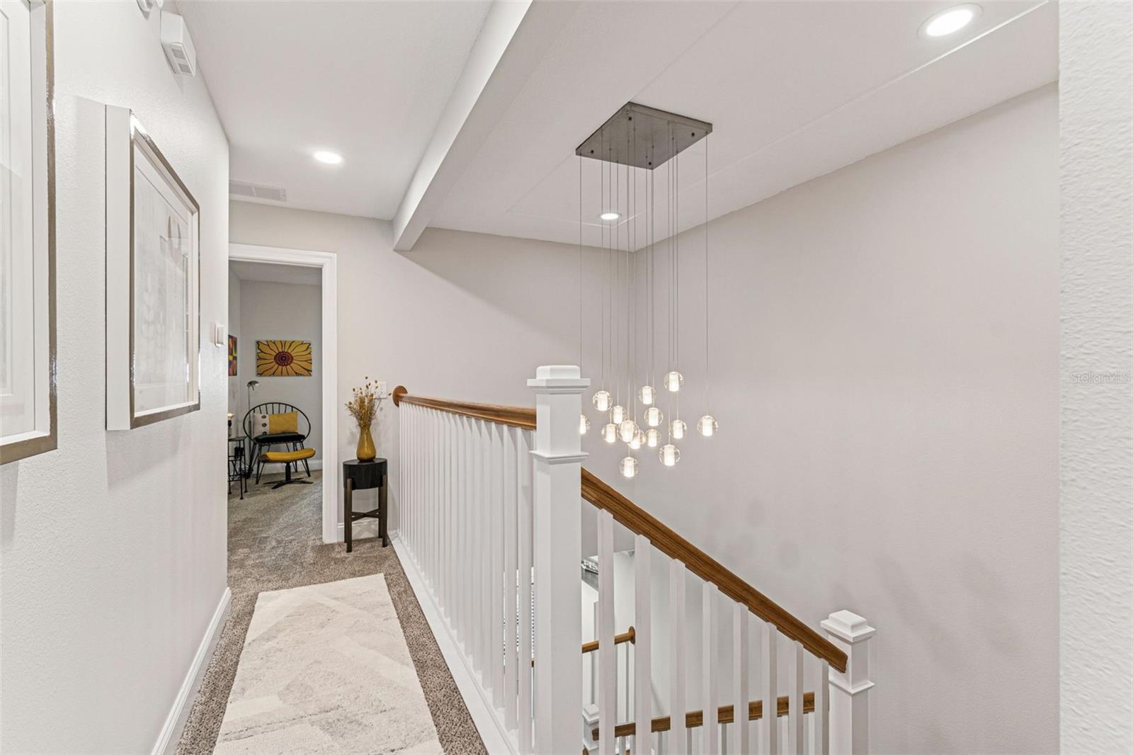 2nd floor hall with view of stunning chandelier and 2nd bedroom