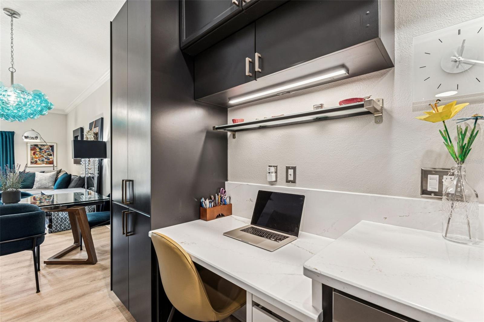 Built-in desk in kitchen area with 2 cabinets above, large pantry and file cabinet