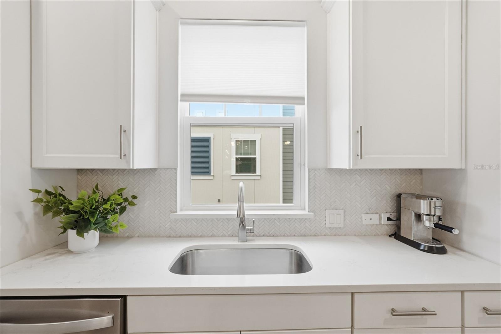 The kitchen features elegant glass-tiled backsplash.