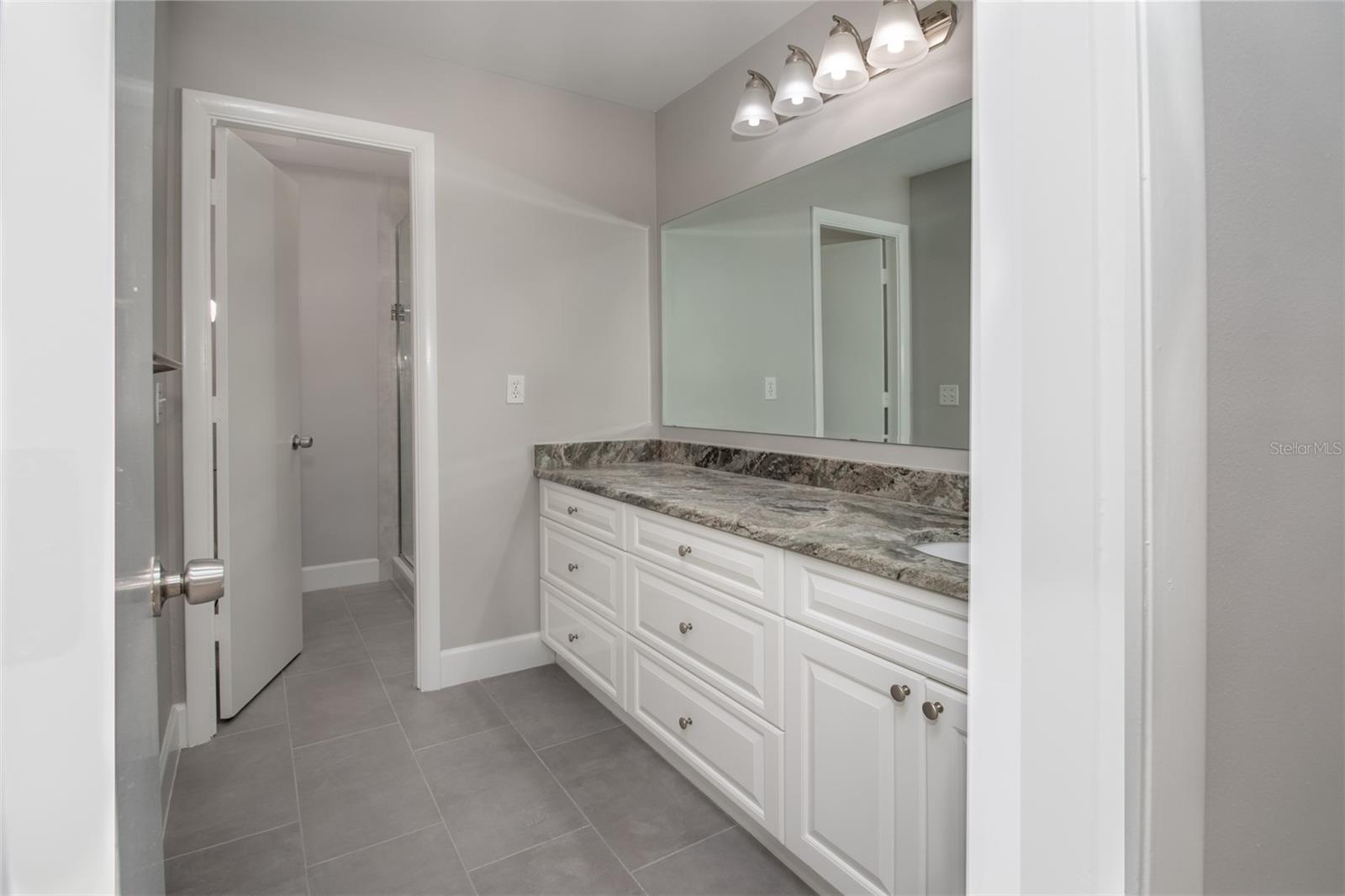 Ensuite bathroom with a 60” frameless glass-enclosed walk-in shower