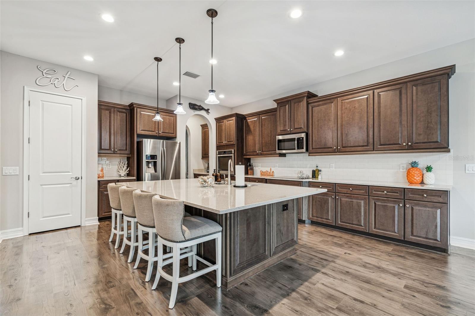 Kitchen featuring an oversized island, walk-in pantry, and ample cabinetry