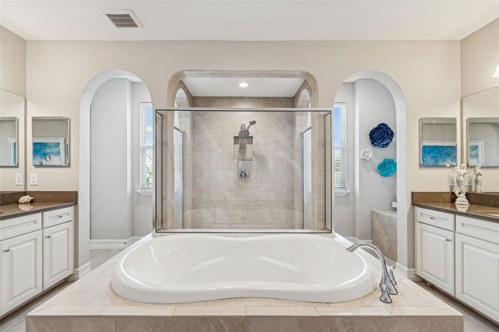 Spa-inspired primary en suite featuring a soaking tub, oversized shower, dual vanities, and generous storage