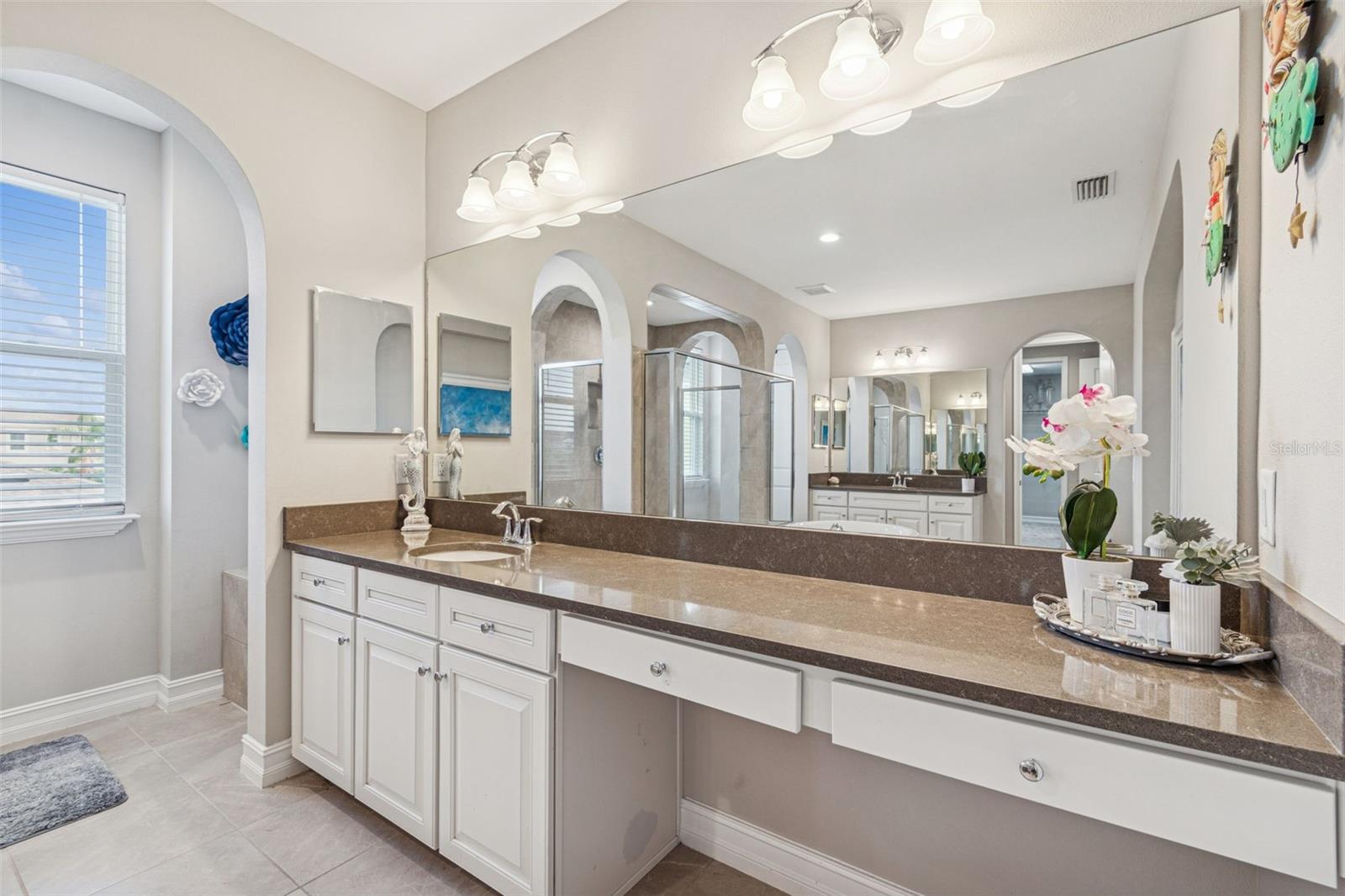 Spa-inspired primary en suite featuring a soaking tub, oversized shower, dual vanities, and generous storage