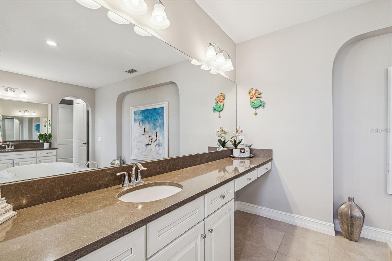 Spa-inspired primary en suite featuring a soaking tub, oversized shower, dual vanities, and generous storage